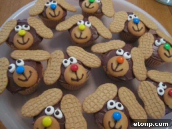 Cute Nutter Butter dog cupcakes featuring peanut butter cookies as floppy ears and chocolate chip noses.
