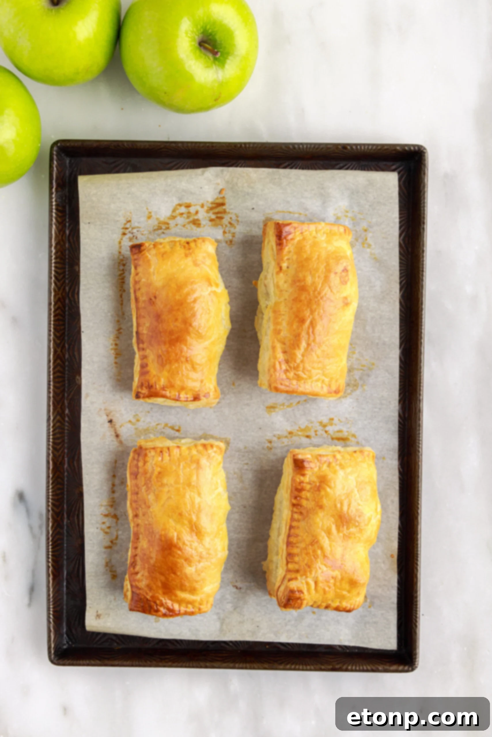 Hand pies sealed with a fork along the edges, ready for the oven.