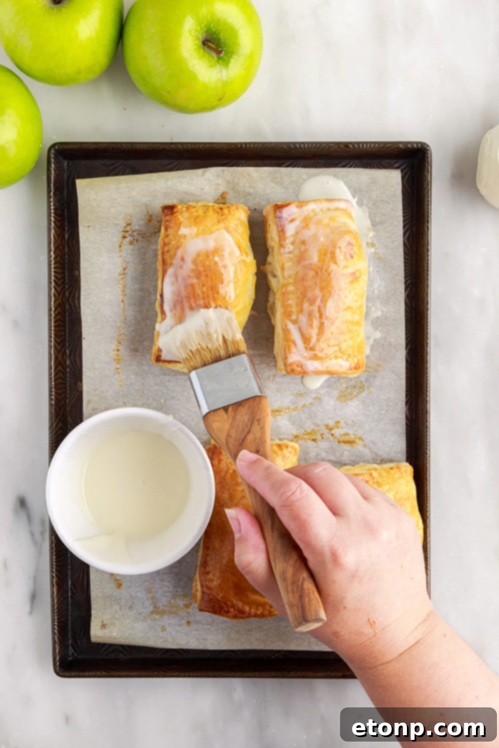 Baked apple hand pies fresh out of the oven, golden and puffed.