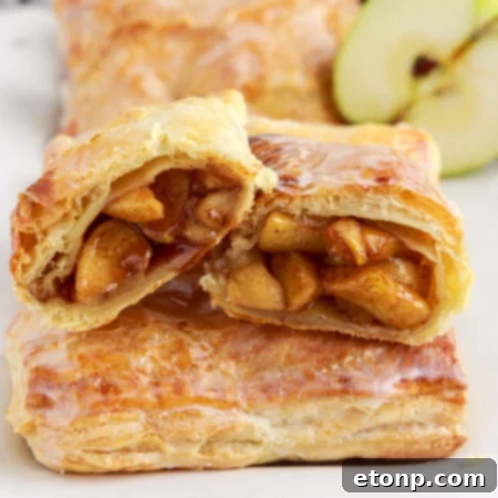 A delicious apple hand pie, sliced to reveal the sweet, tender apple filling inside.