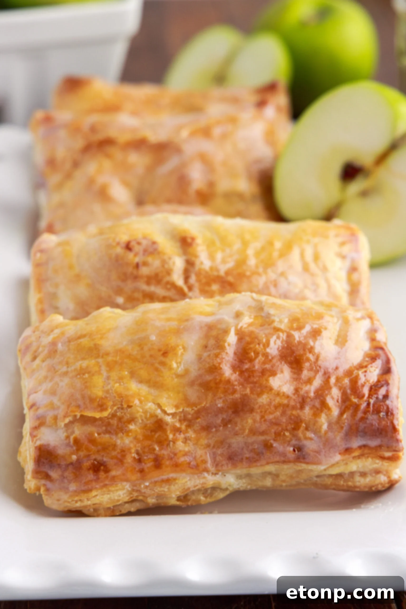 A close-up view of an individual apple hand pie, showcasing its beautifully crimped edges and a hint of the delicious filling.