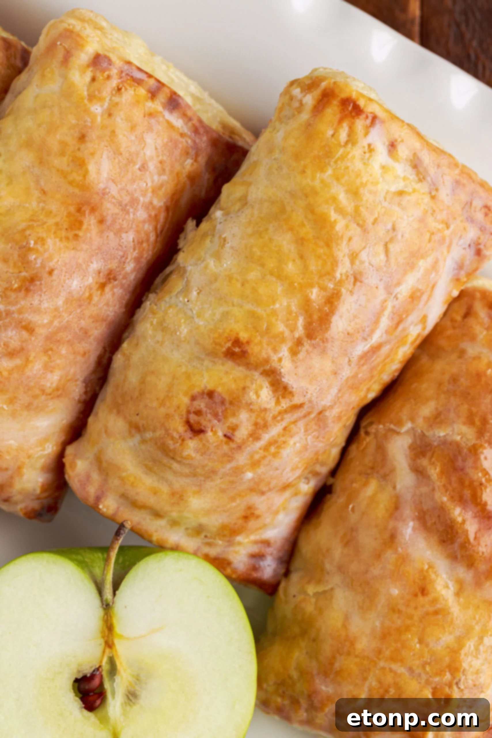 An inviting overhead view of a single apple hand pie, perfectly glazed and featuring a rich, golden-brown crust.