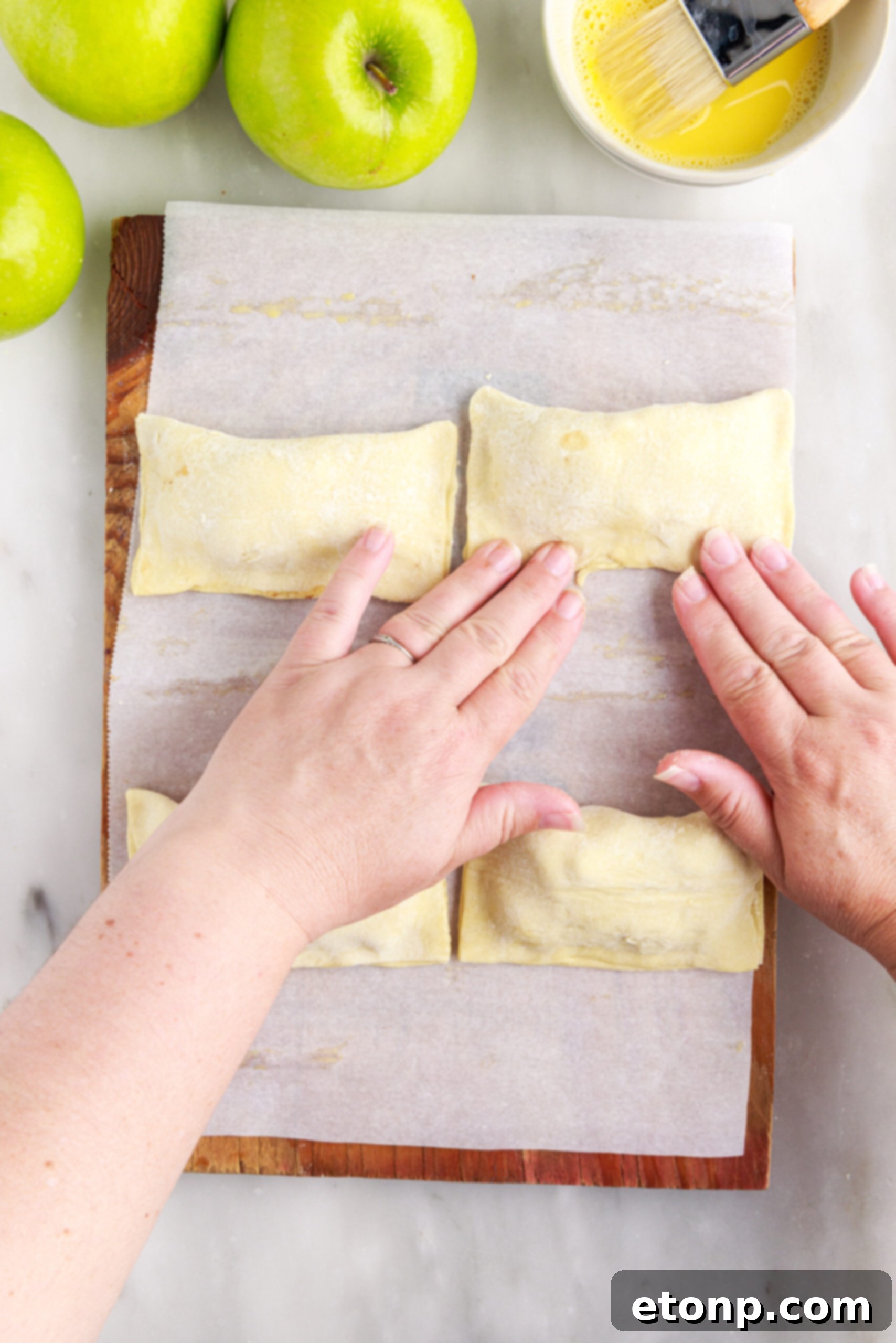 Pastry edges brushed with egg wash for sealing.
