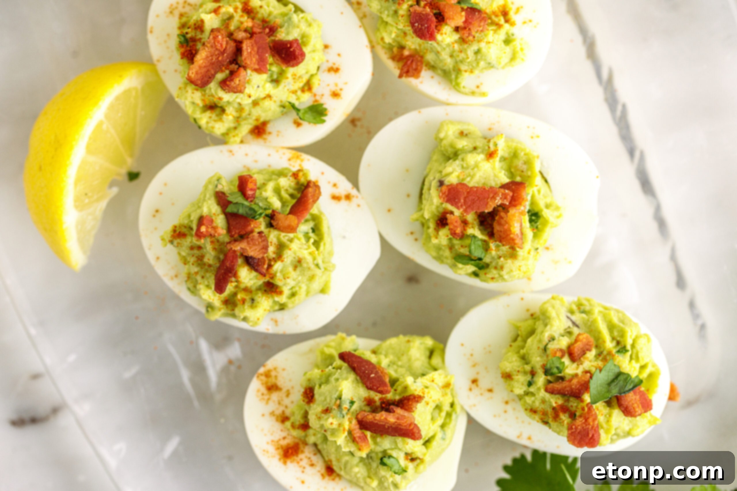 Overhead view of the deviled eggs topped with with chopped bacon. 