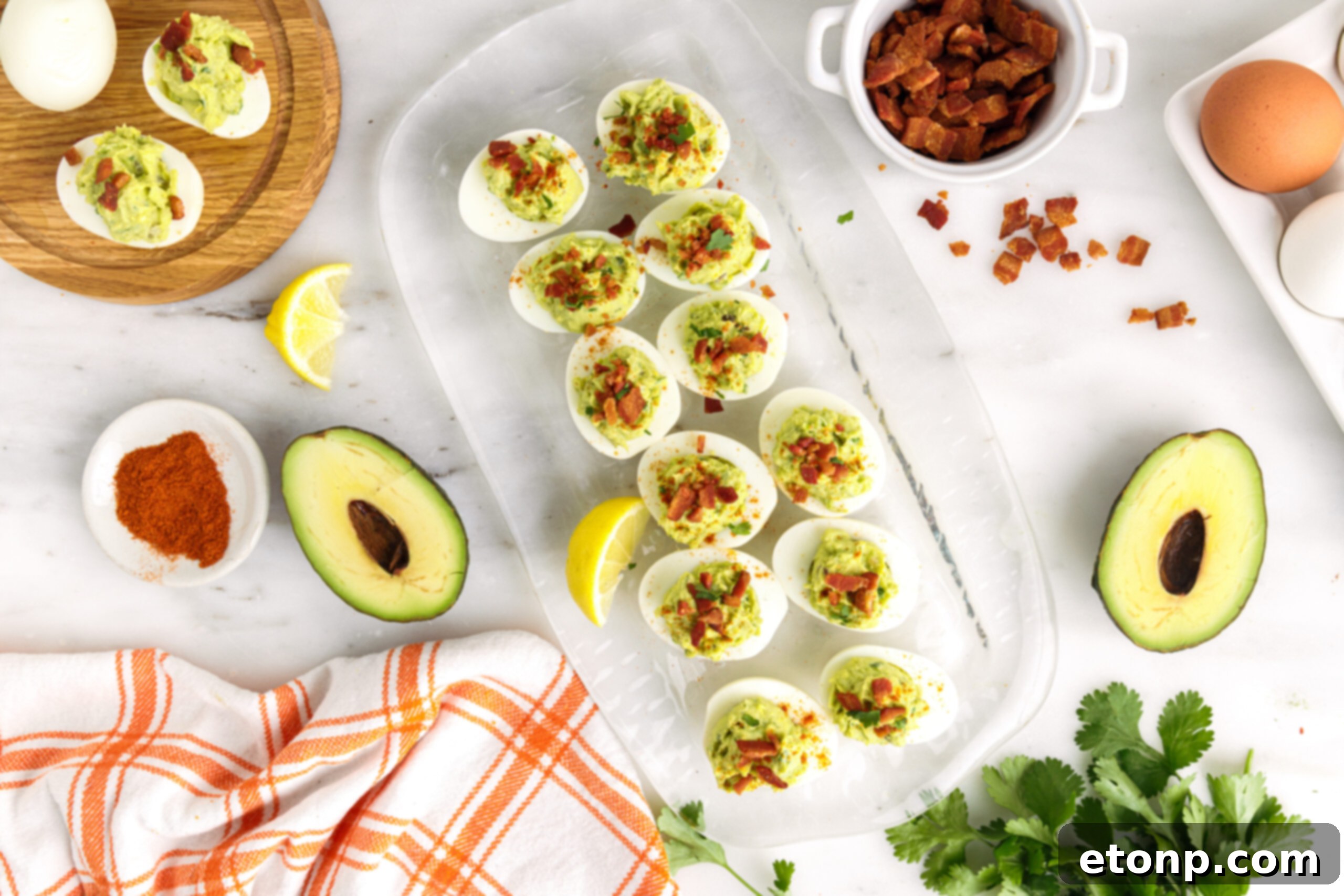 Overhead shot of one dozen avocado deviled eggs on a clear serving tray. 