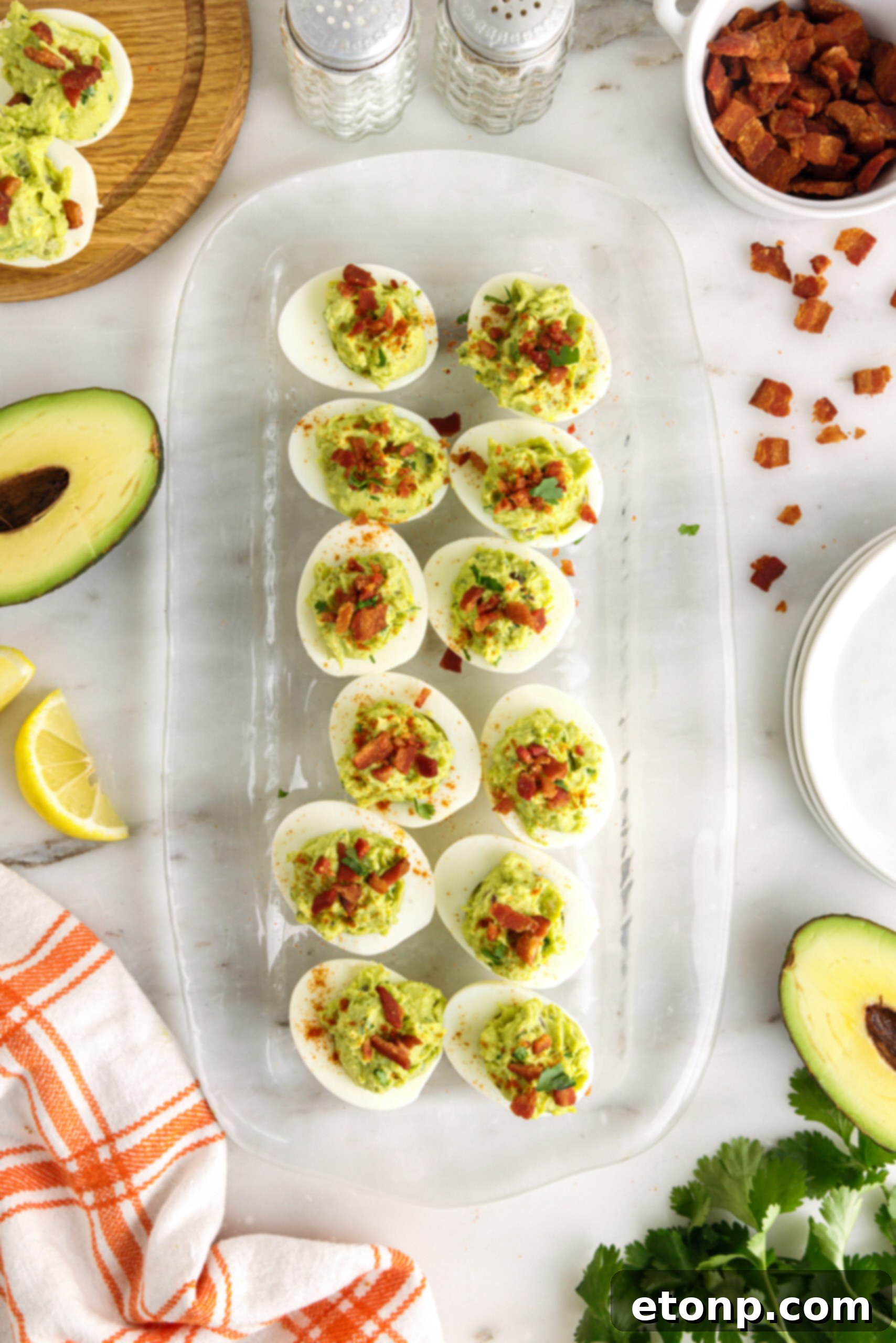 Overhead shot of one dozen avocado deviled eggs on a clear serving tray. 
