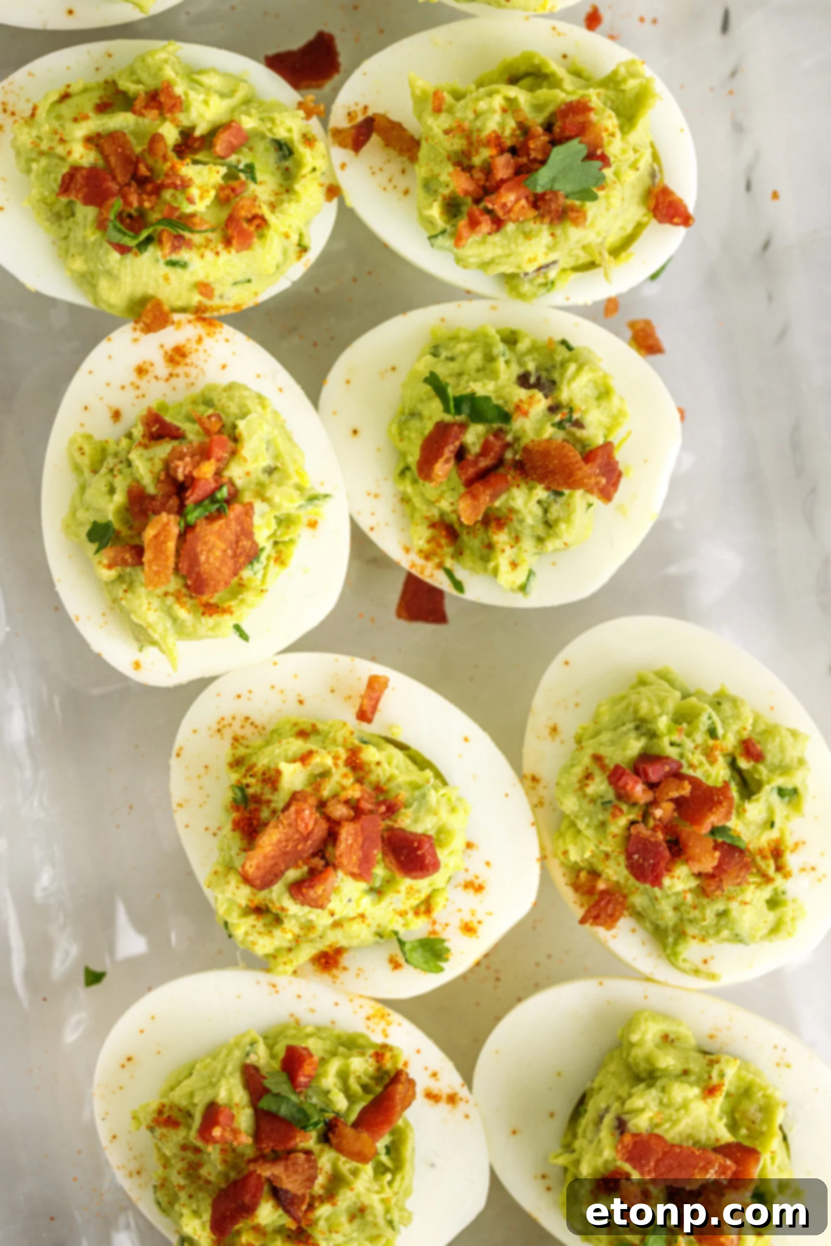 Overhead view of the deviled eggs topped with with chopped bacon. 