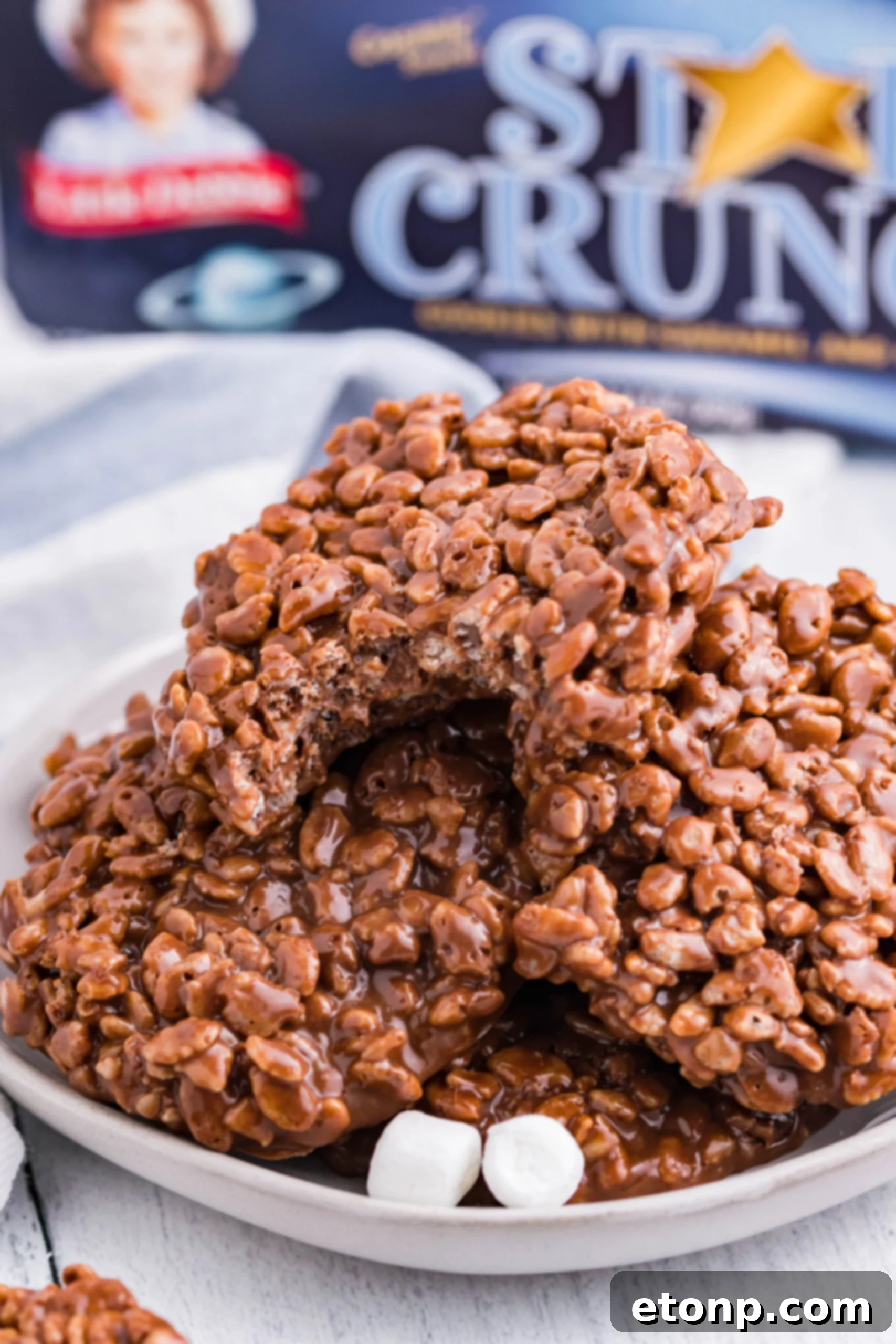 Star Crunch Copycat Cookies stacked on a white plate with marshmallows. 