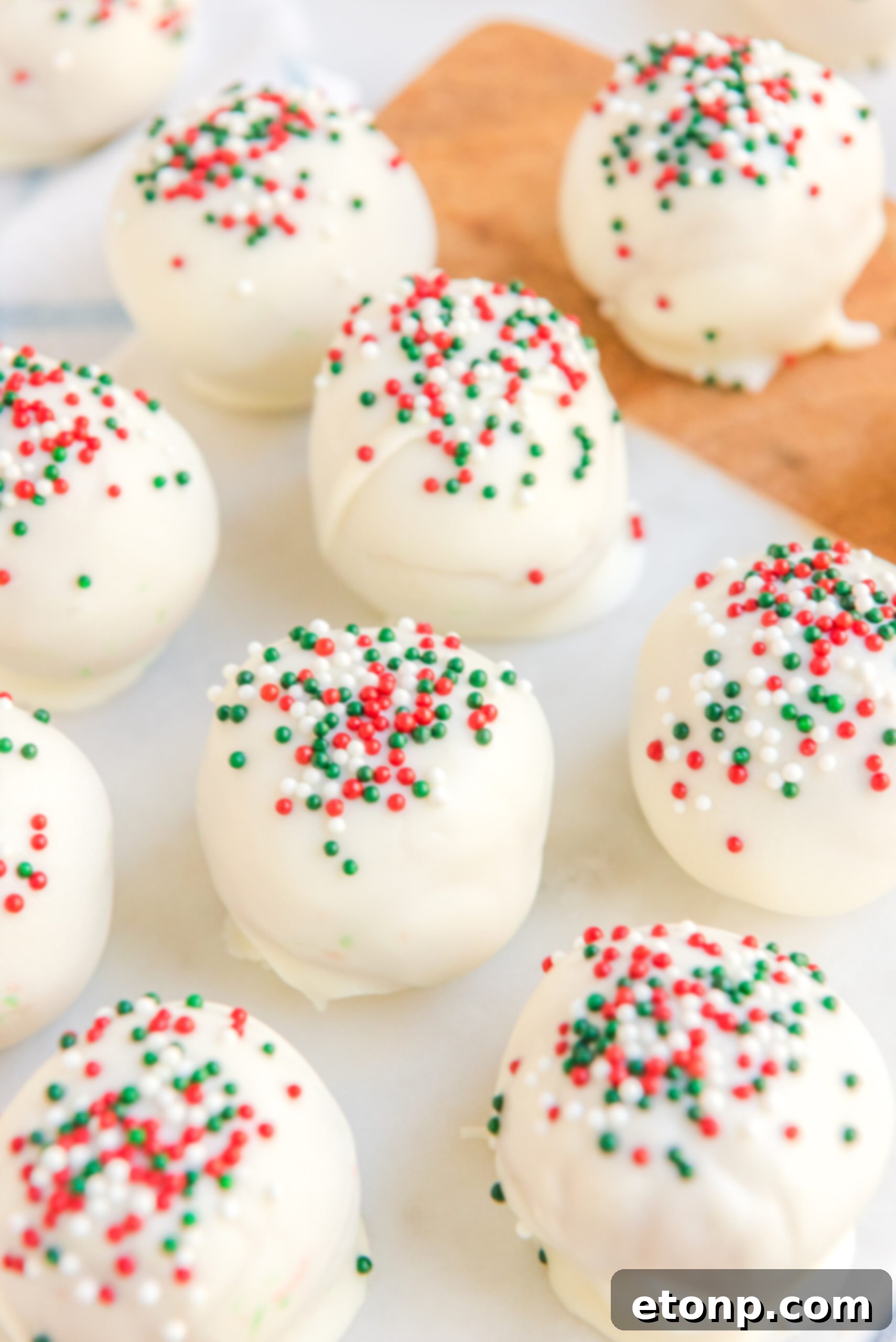 Irresistible White Chocolate Peanut Butter Snowballs 4 Another close-up of the white chocolate peanut butter truffles, adorned with vibrant red, white, and green sprinkles, ready for the holidays.