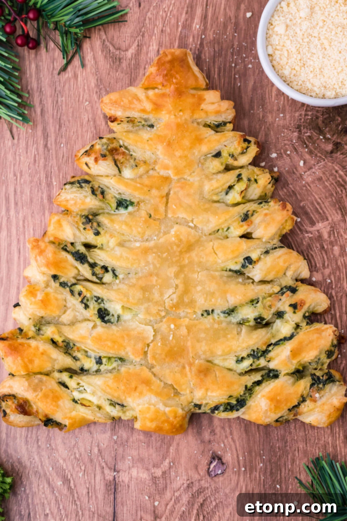 Overhead view of spinach dip pull apart Christmas tree bread on a dark wood background. 