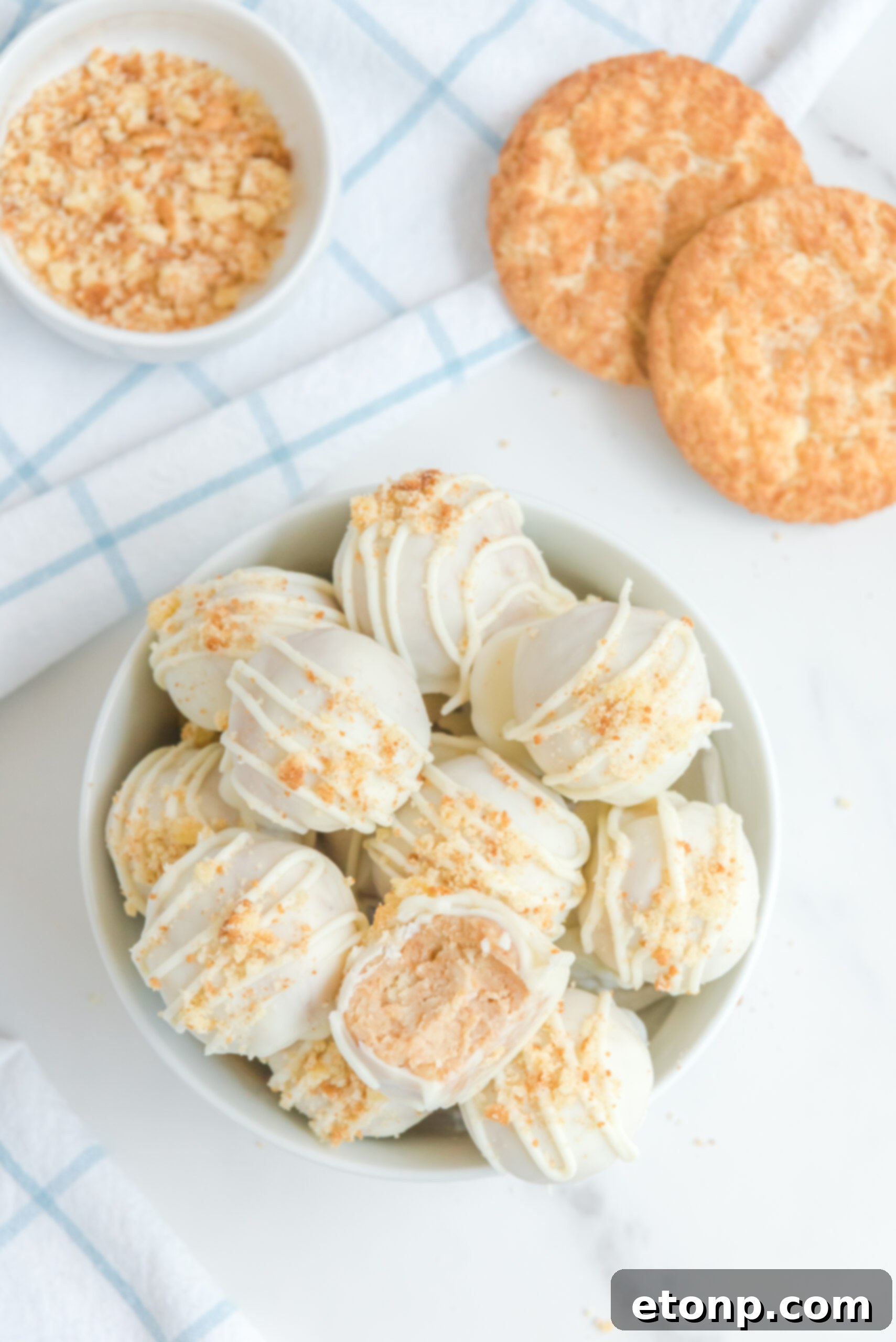 An overhead shot of snickerdoodle truffles in a white bowl topped with crushed snickerdoodles.