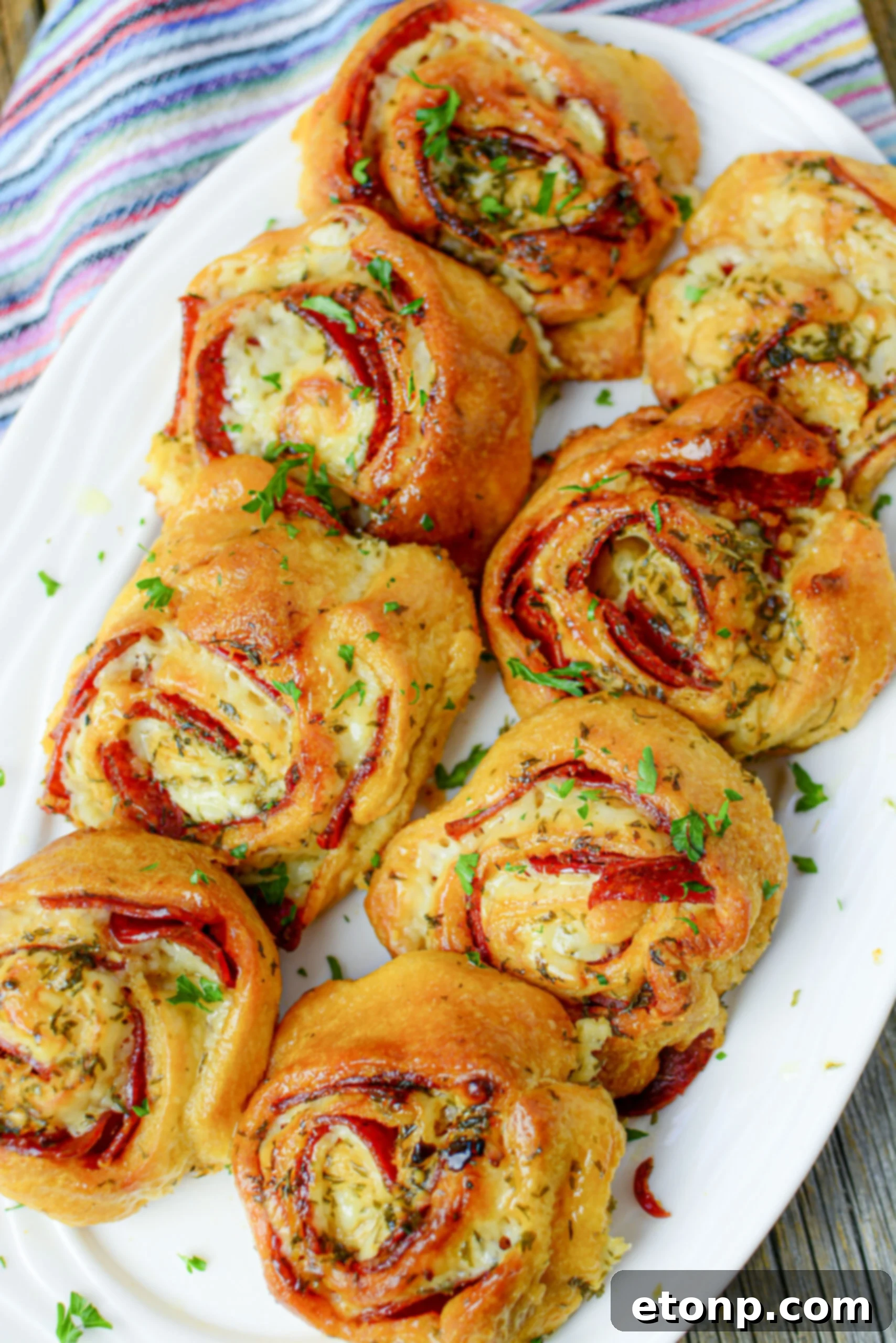 Pizza Swirls 4 Artistically arranged pizza pinwheels, showing their golden crusts and savory fillings on a rustic background.