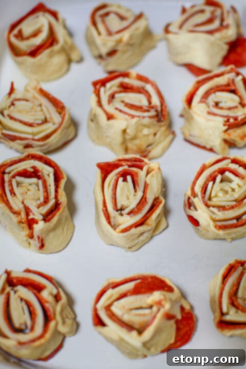 Pizza Swirls 9 A vibrant pizza pinwheel on a plate, highlighting its colorful layers of ingredients.