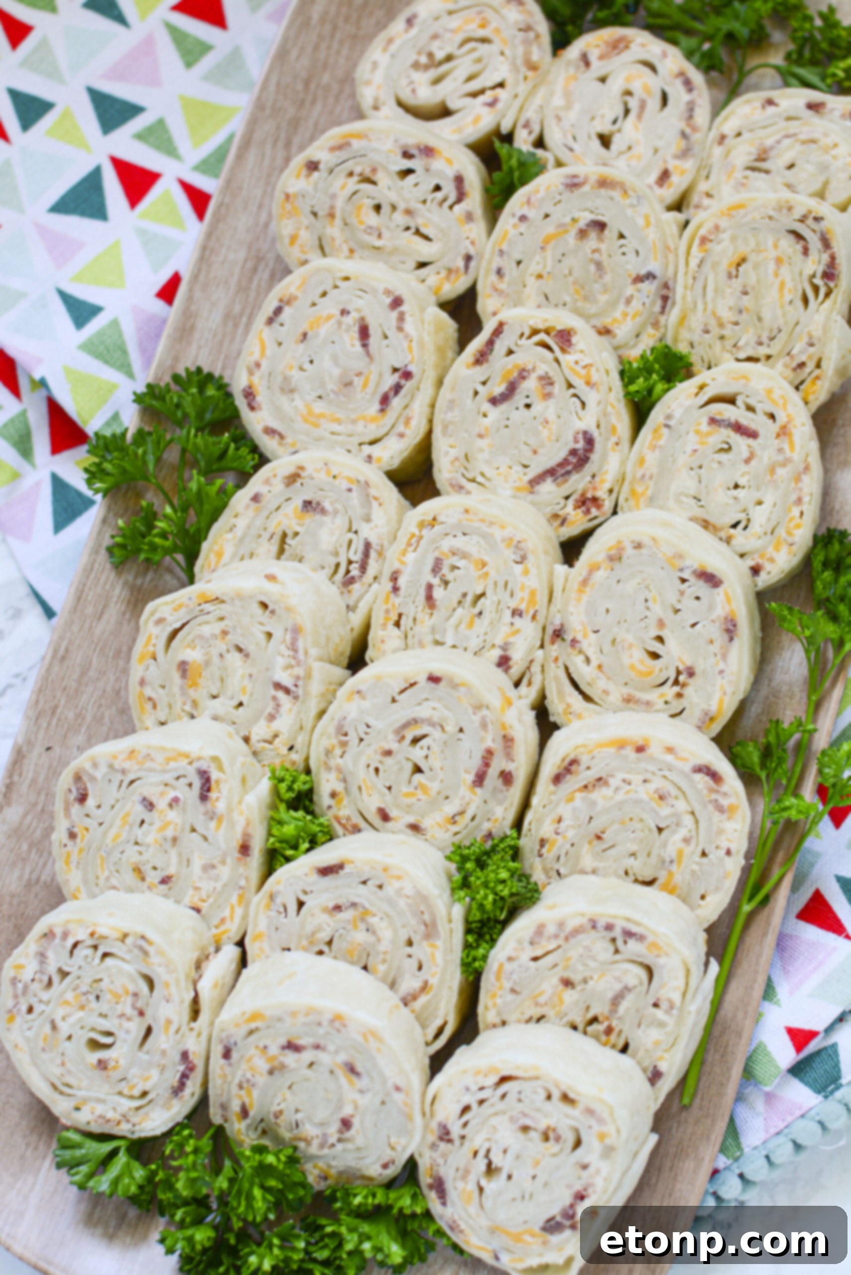 Ingredients for turkey pinwheels laid out on a table: turkey slices, cream cheese, cheddar, bacon, ranch powder, and tortillas.