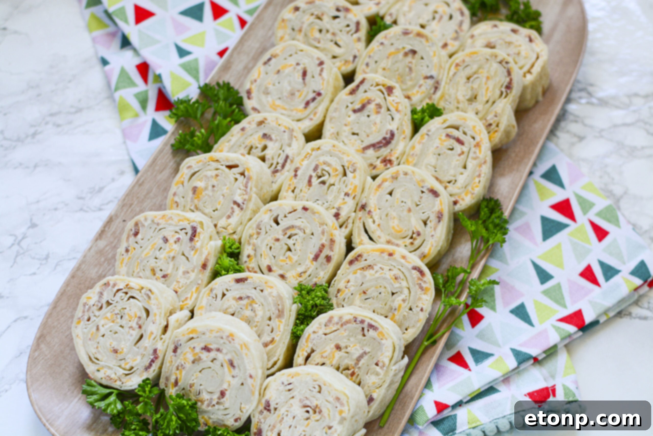 Overhead shot of a full platter of freshly cut turkey pinwheels, ready for serving.
