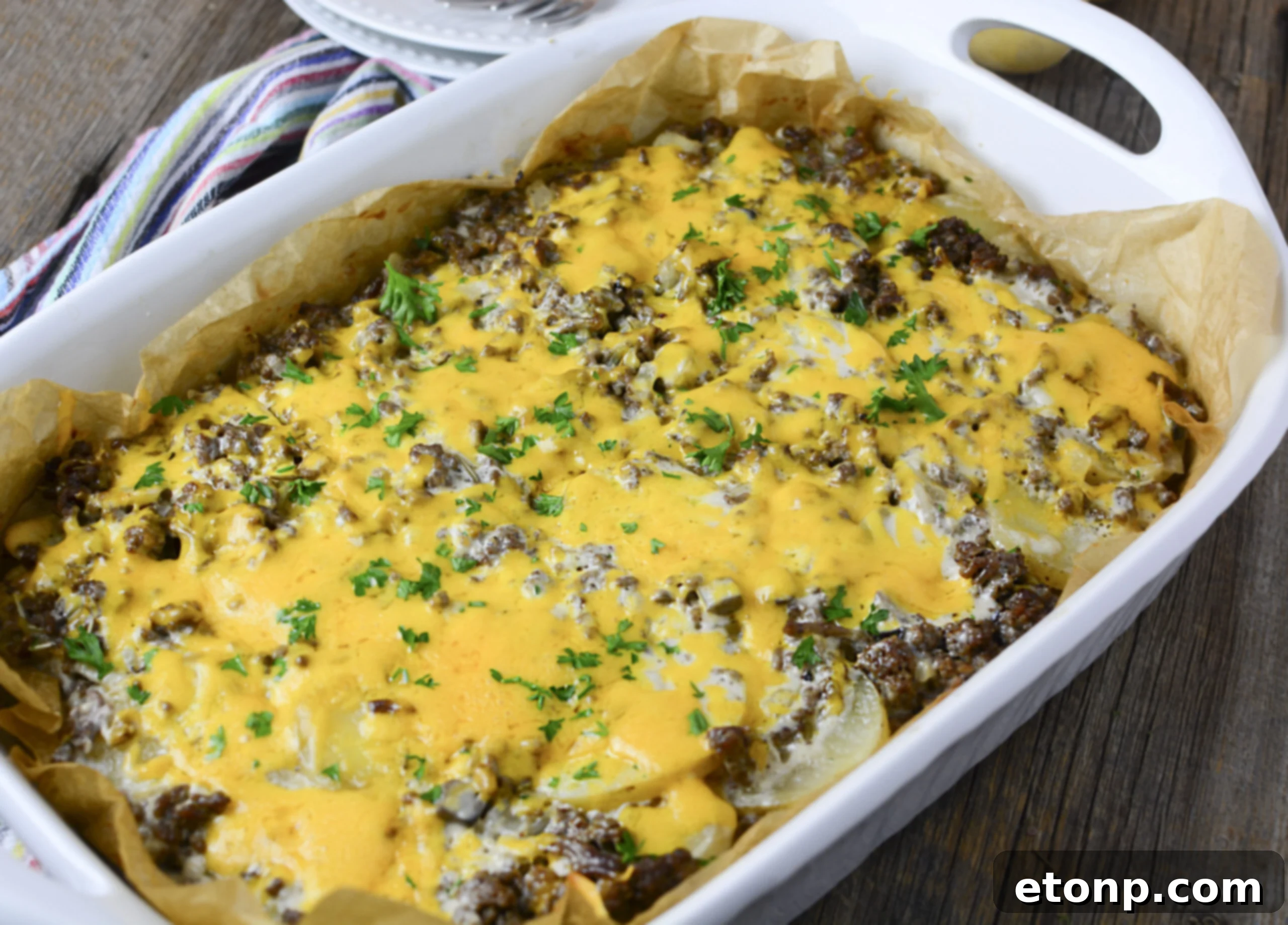 A side view of the rich, Cheesy Ground Beef and Potato Casserole, showcasing its delicious layers in a white baking dish.