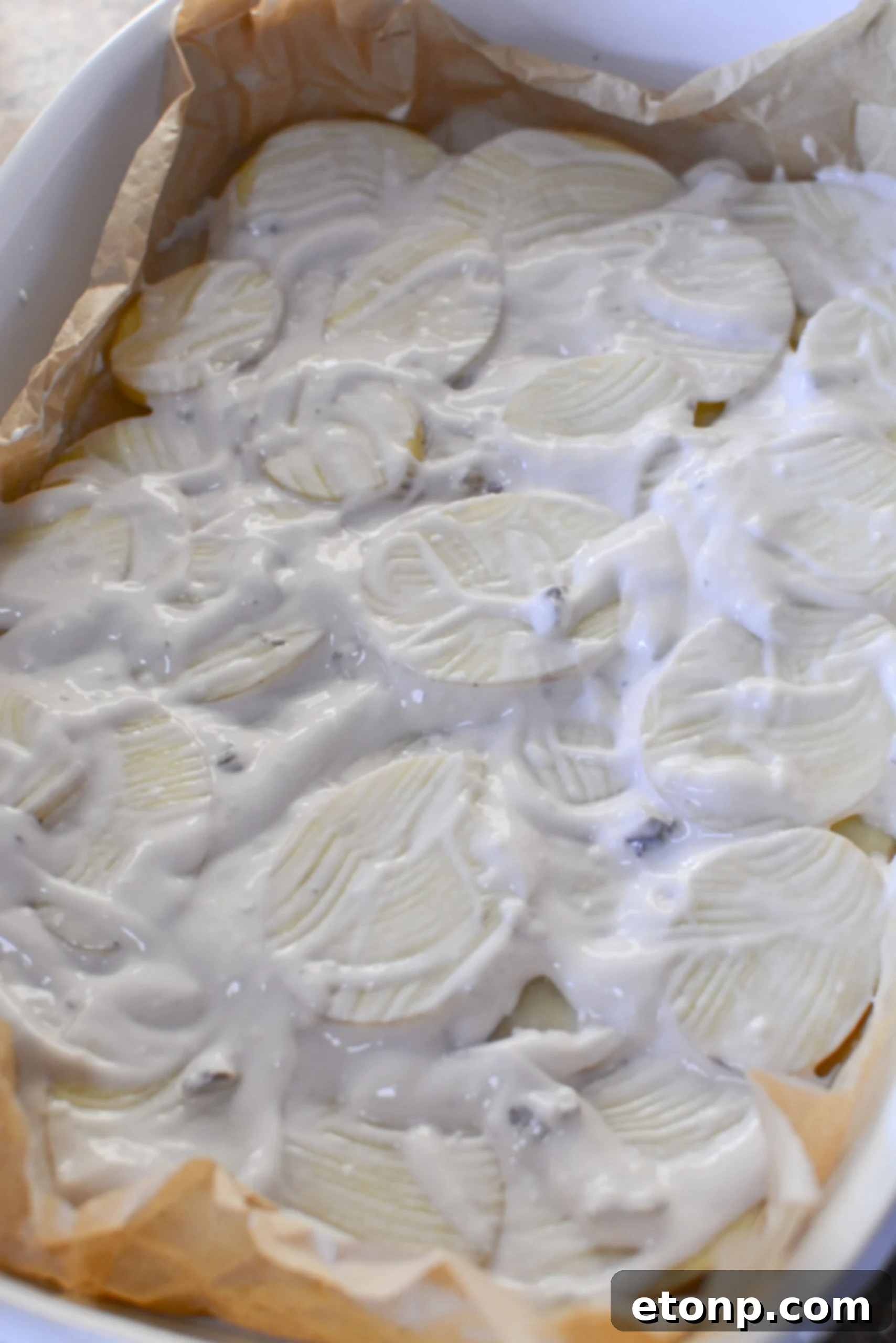 Distributing cheese evenly over the casserole layers.