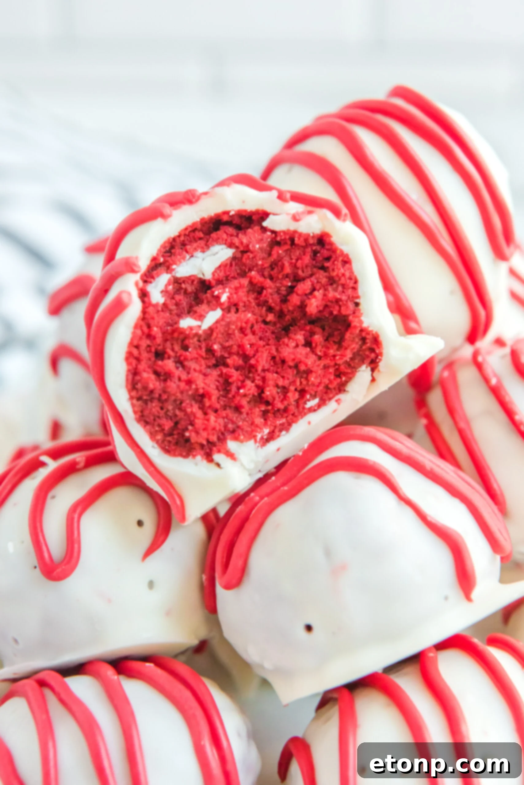 Close up of a bite removed from a red velvet cake ball.