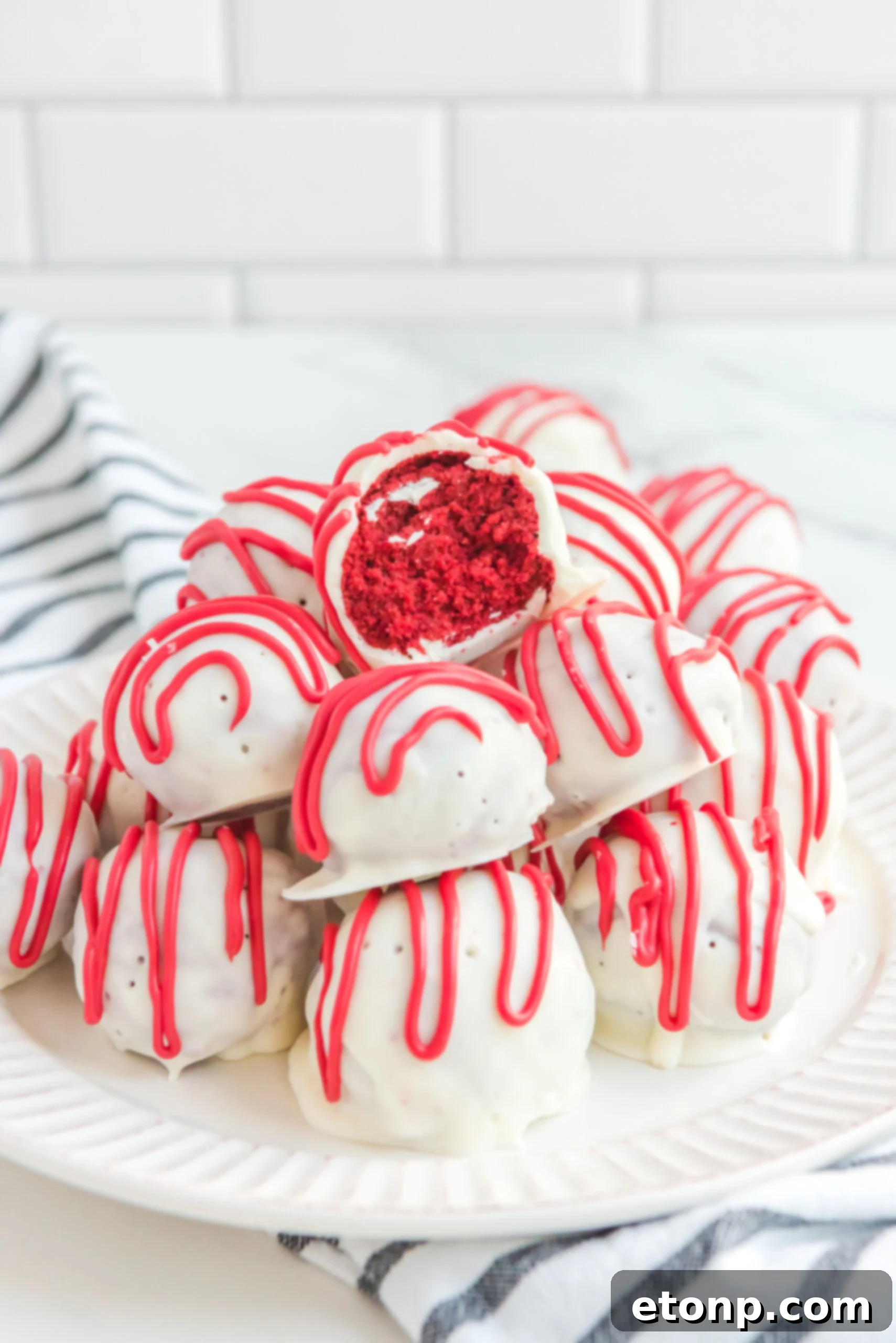 A large bowl filled with red velvet cake balls with the center ball with a bite removed.