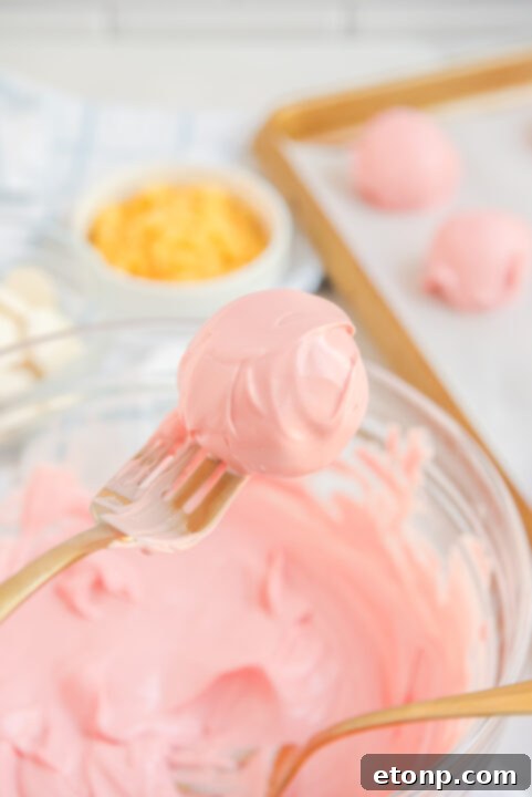 Step-by-step image of dipping a truffle ball into melted pink candy.