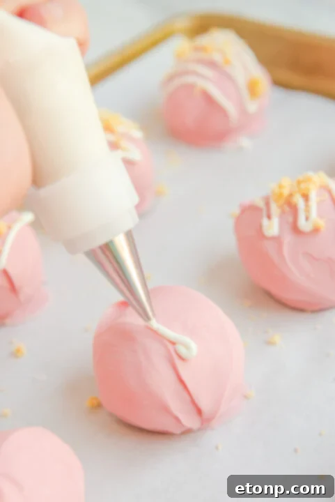 Step-by-step image of drizzling white chocolate over the pink-coated truffles.