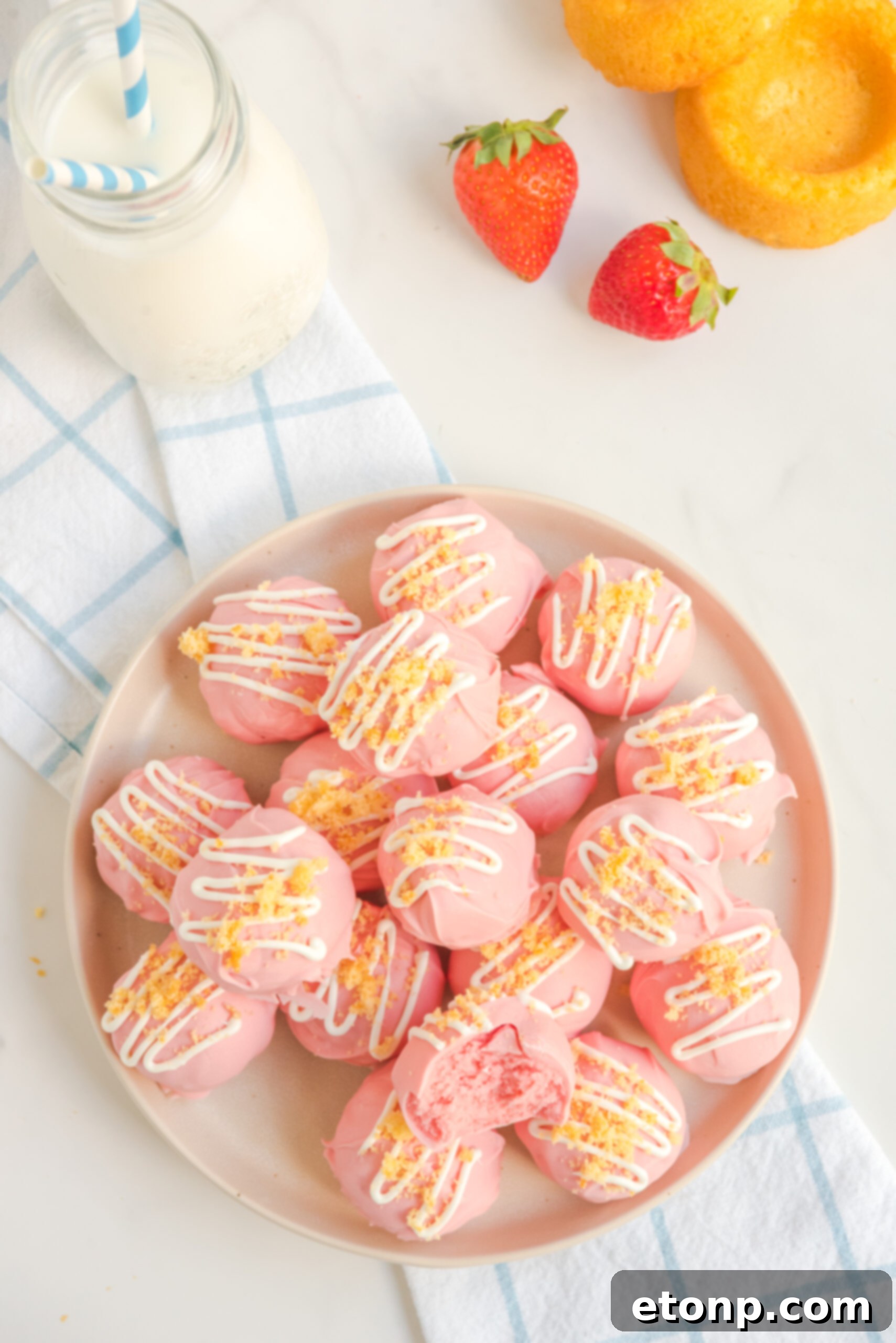 Overhead view of perfectly arranged strawberry shortcake truffles on a white plate, ready to be served.