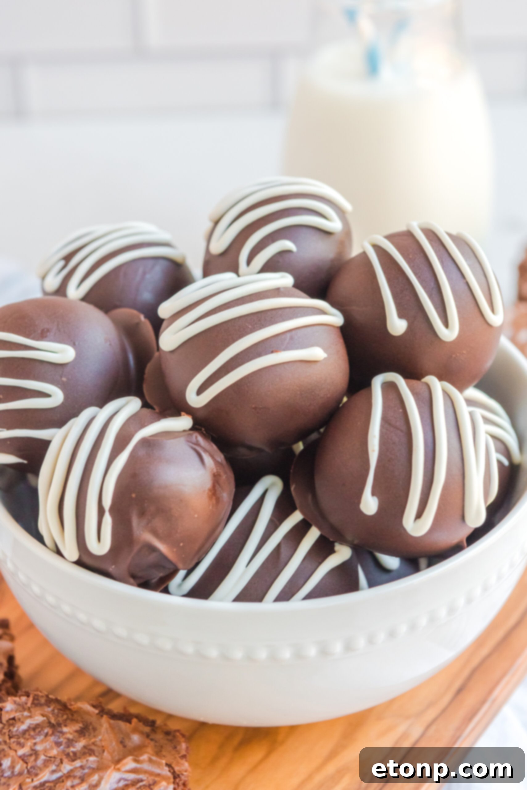 Decadent Brownie Truffles 7 An intimate, close-up photograph of Brownie Bite Truffles nestled in a pristine white bowl, highlighting their exquisite texture and tempting appearance.