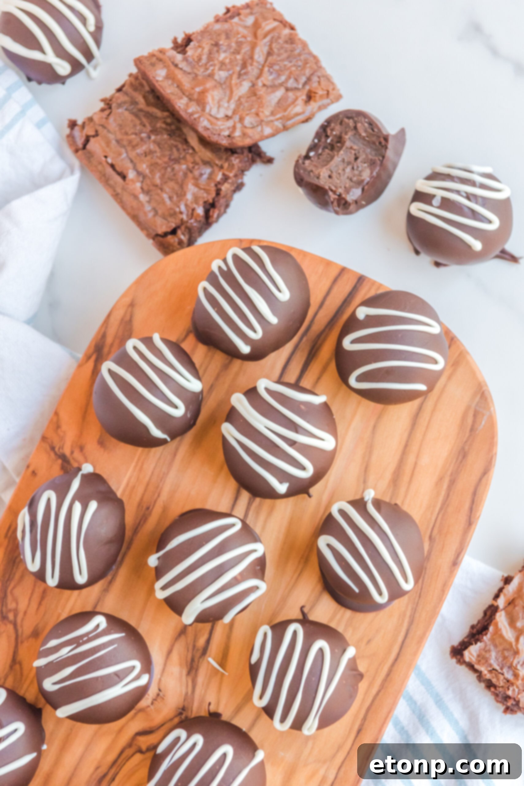 Decadent Brownie Truffles 10 An overhead shot showcasing Brownie Truffles elegantly arranged on a rustic wooden serving board, with a blurred backdrop of additional brownies, emphasizing their handcrafted beauty.