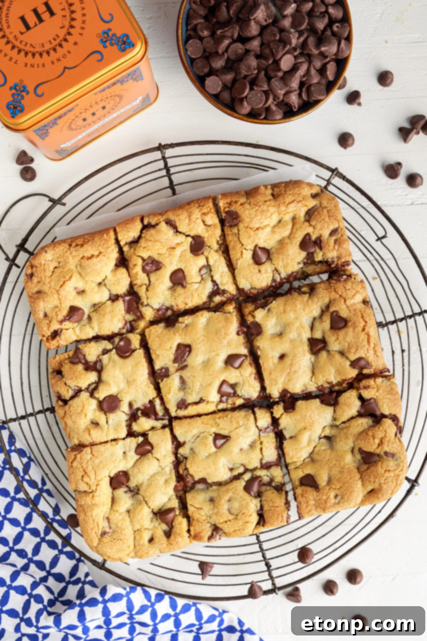 Overhead view of nine perfectly cut gooey chocolate chip cookie bars cooling on a wire rack.