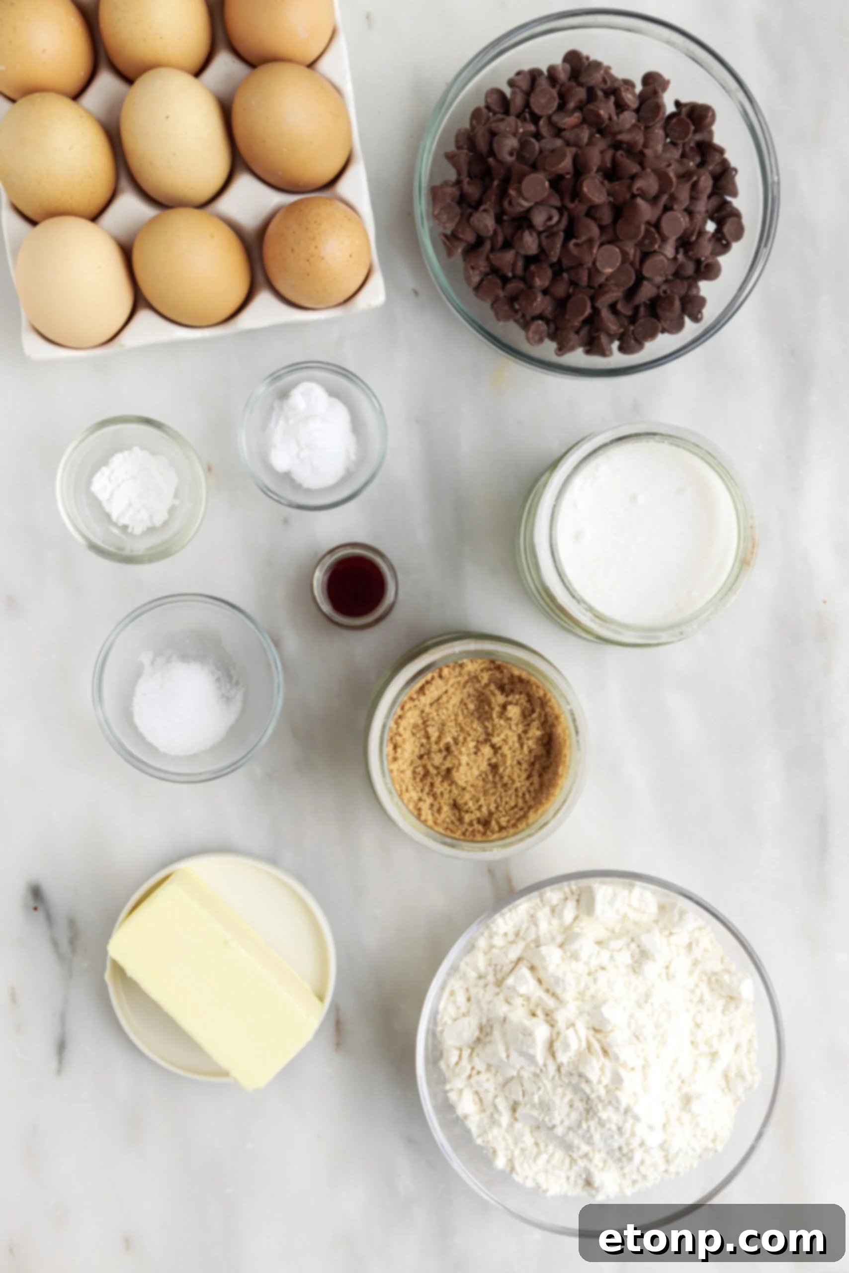Overhead view of all the essential ingredients artfully laid out on a surface, ready for making gooey chocolate chip cookie bars.