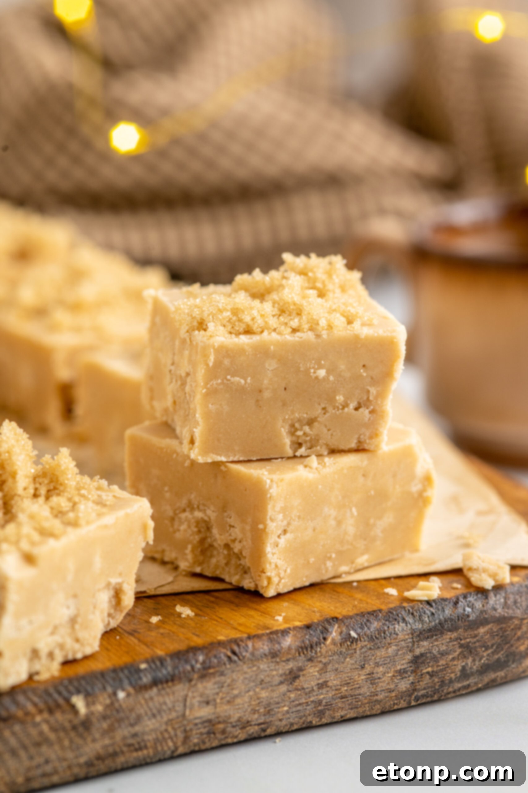 Golden Caramel Fudge 14 2 pieces of Penuche Fudge on a wooden board.