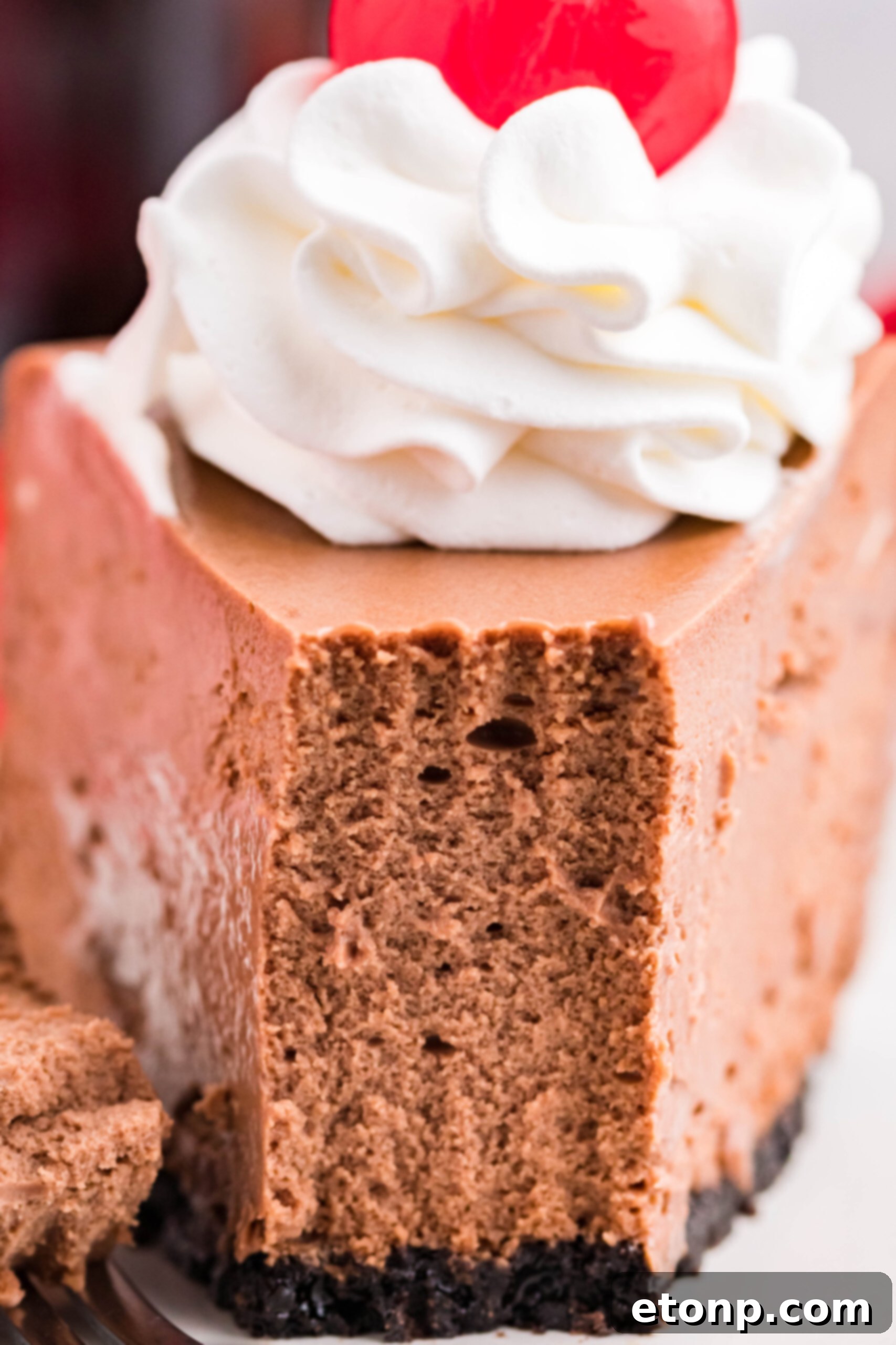 Decadent Coca-Cola Cheesecake 9 Front view of a slice of Coca Cola Cheesecake with a piece removed by a fork.