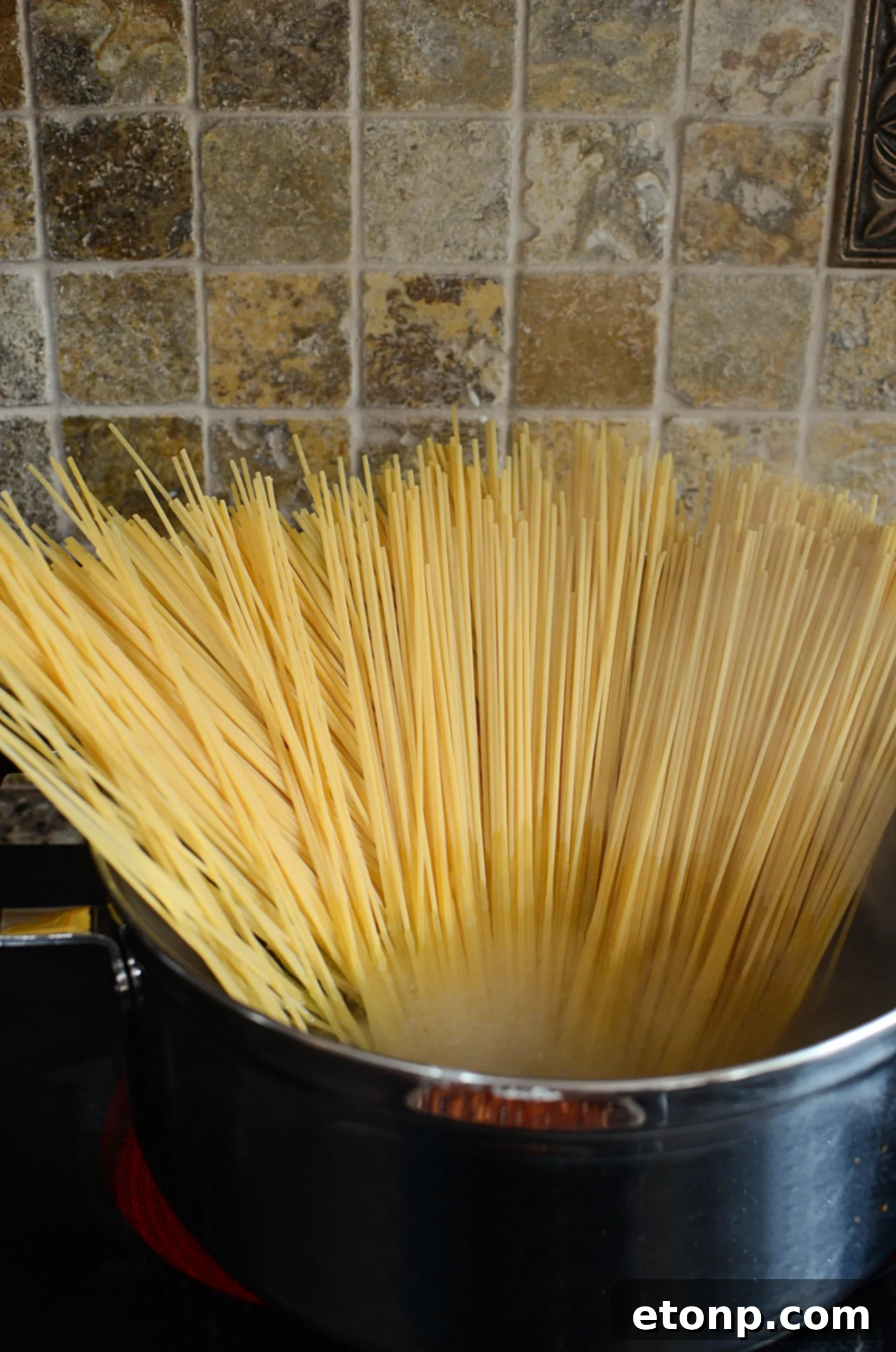 Crown Jewel Spaghetti 5 Cooked spaghetti being mixed with creamy cheese sauce for Million Dollar Spaghetti