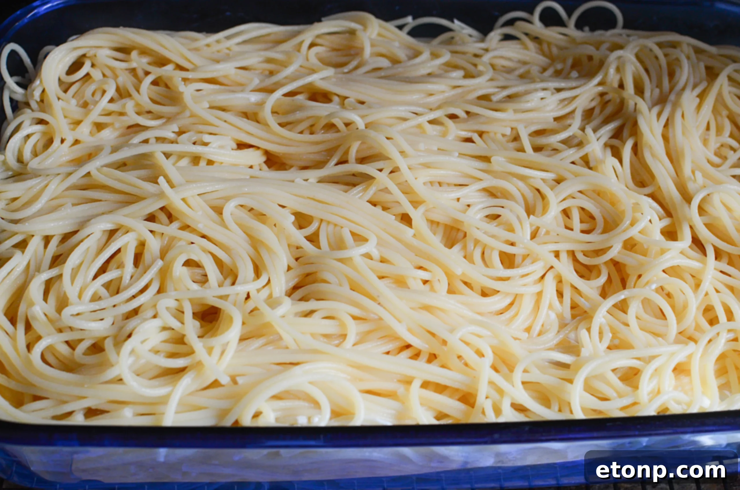 Crown Jewel Spaghetti 7 Close-up of the creamy cheese mixture being spread onto cooked spaghetti