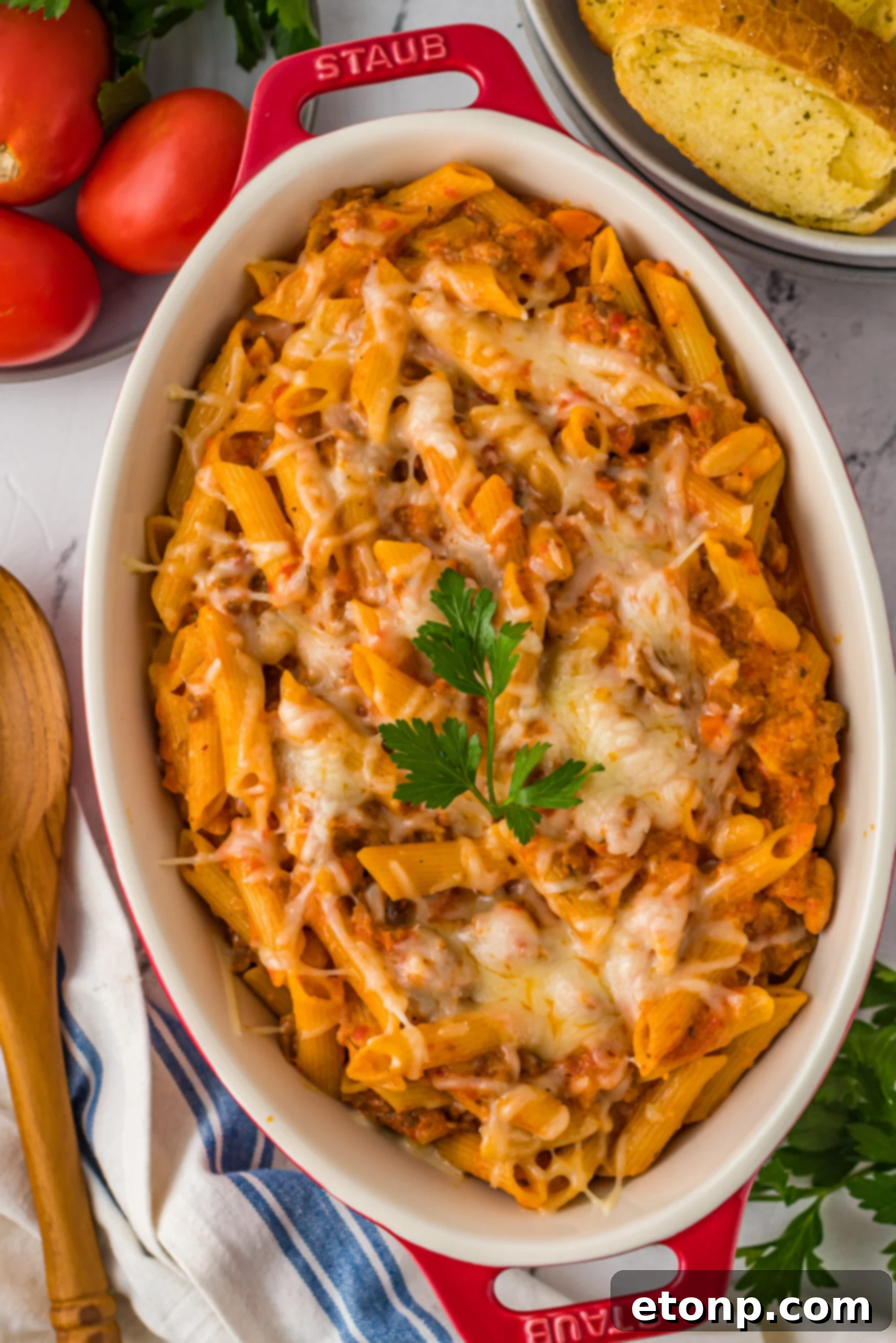Overhead view of a freshly baked Pasta Fagioli al Forno in a rustic baking dish, garnished with fresh herbs.