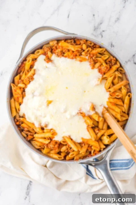 Mozzarella cheese sprinkled generously over the pasta before baking.