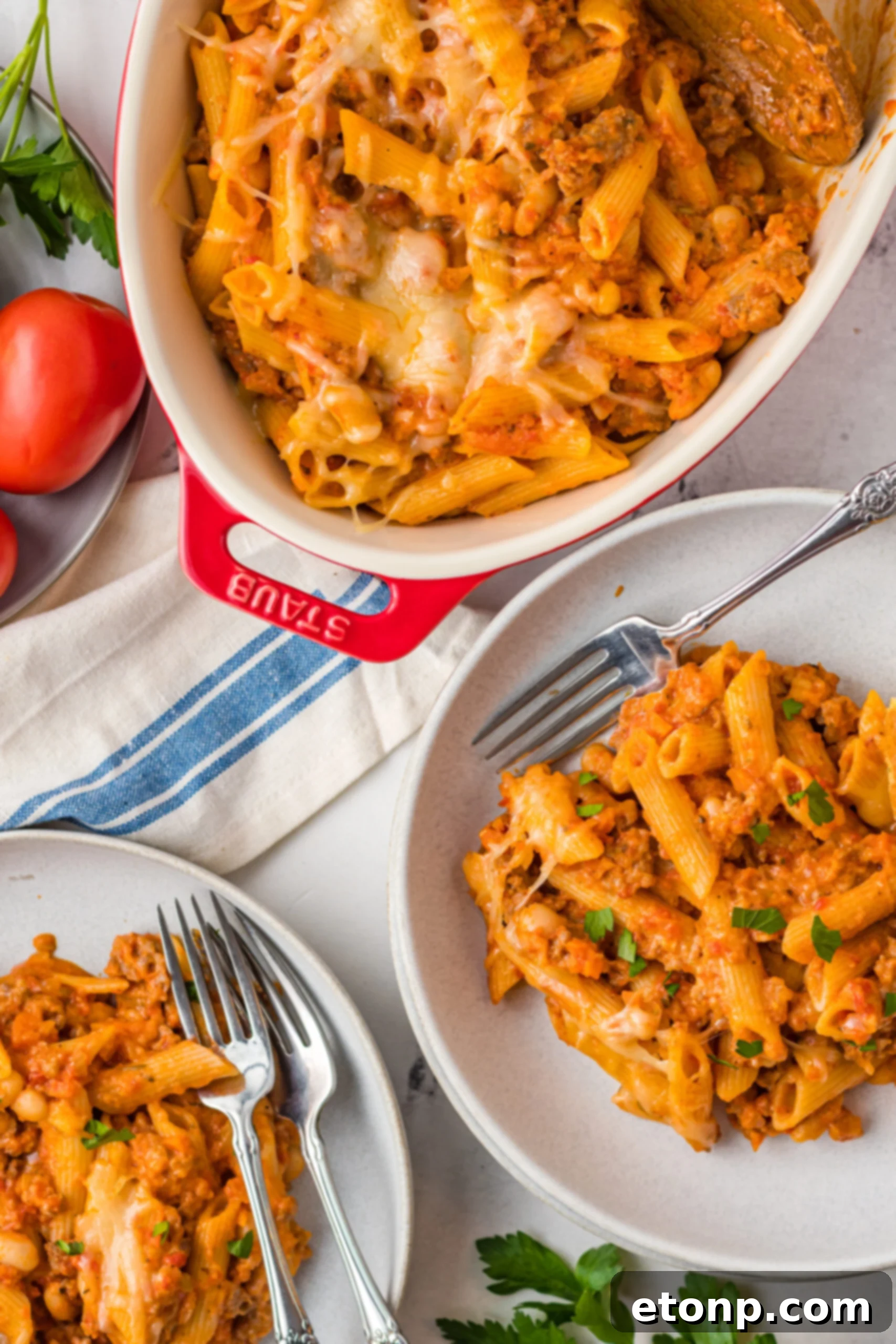 Two generous servings of Pasta Fagioli al Forno on gray plates with silver forks, ready for a comforting meal.