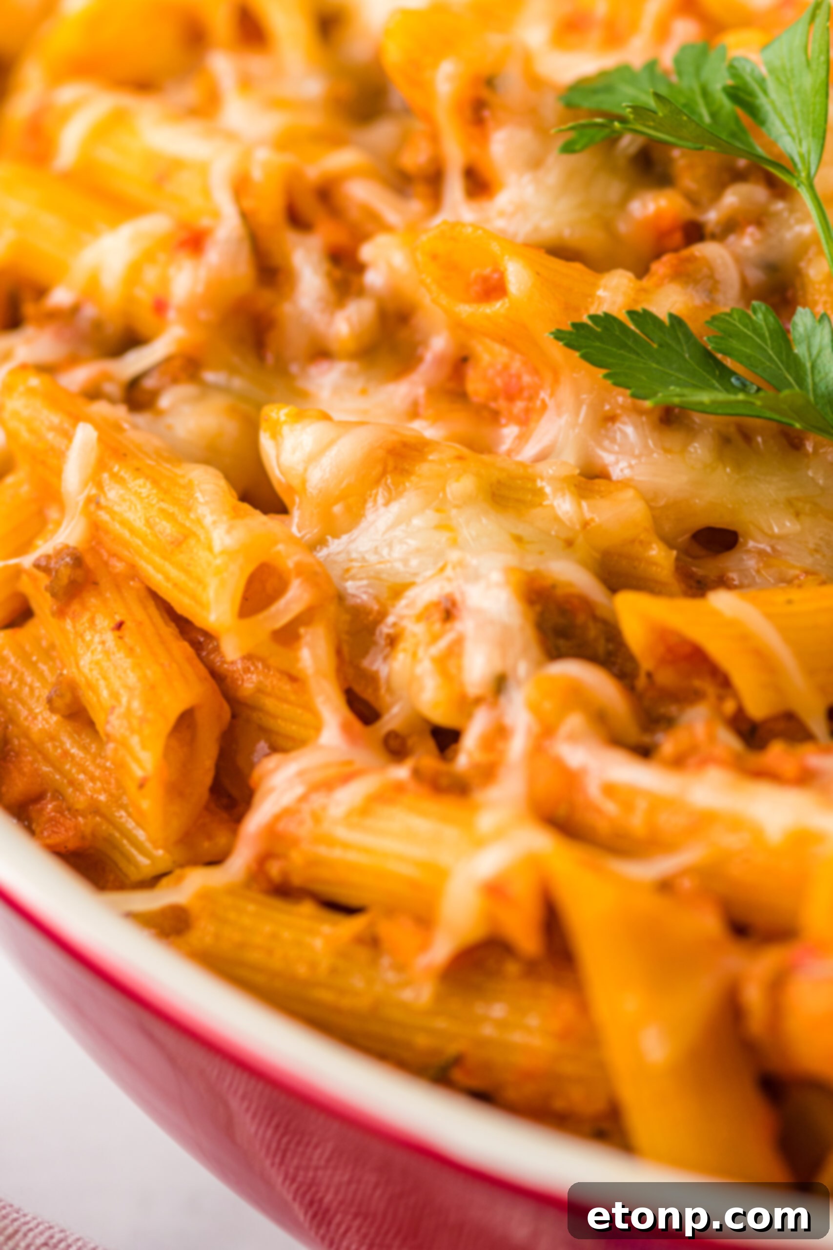 Close up view of the bubbling, cheesy top of Pasta Fagioli al Forno, fresh from the oven.