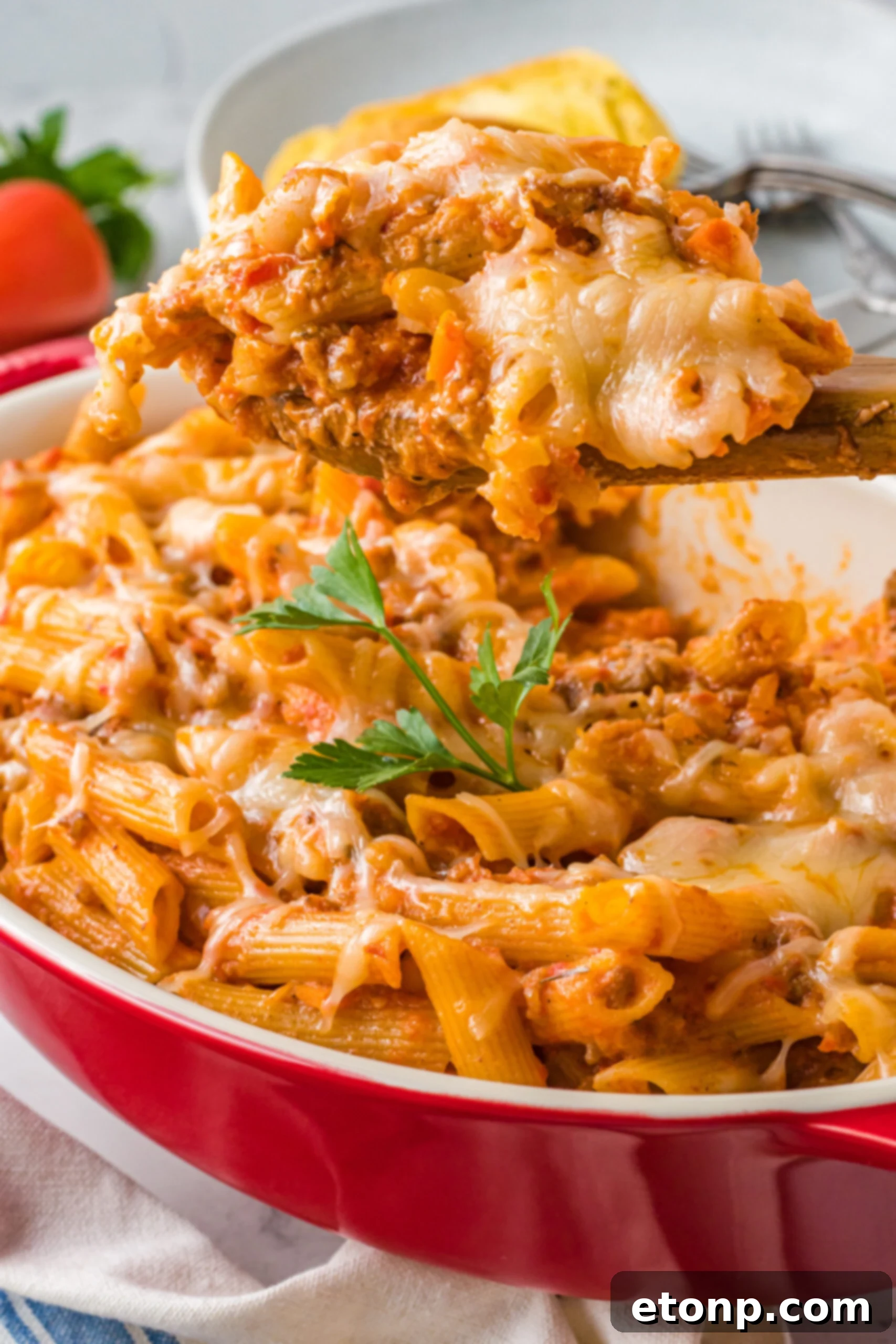 A serving of Pasta Fagioli al Forno rests in a white bowl, steam gently rising.