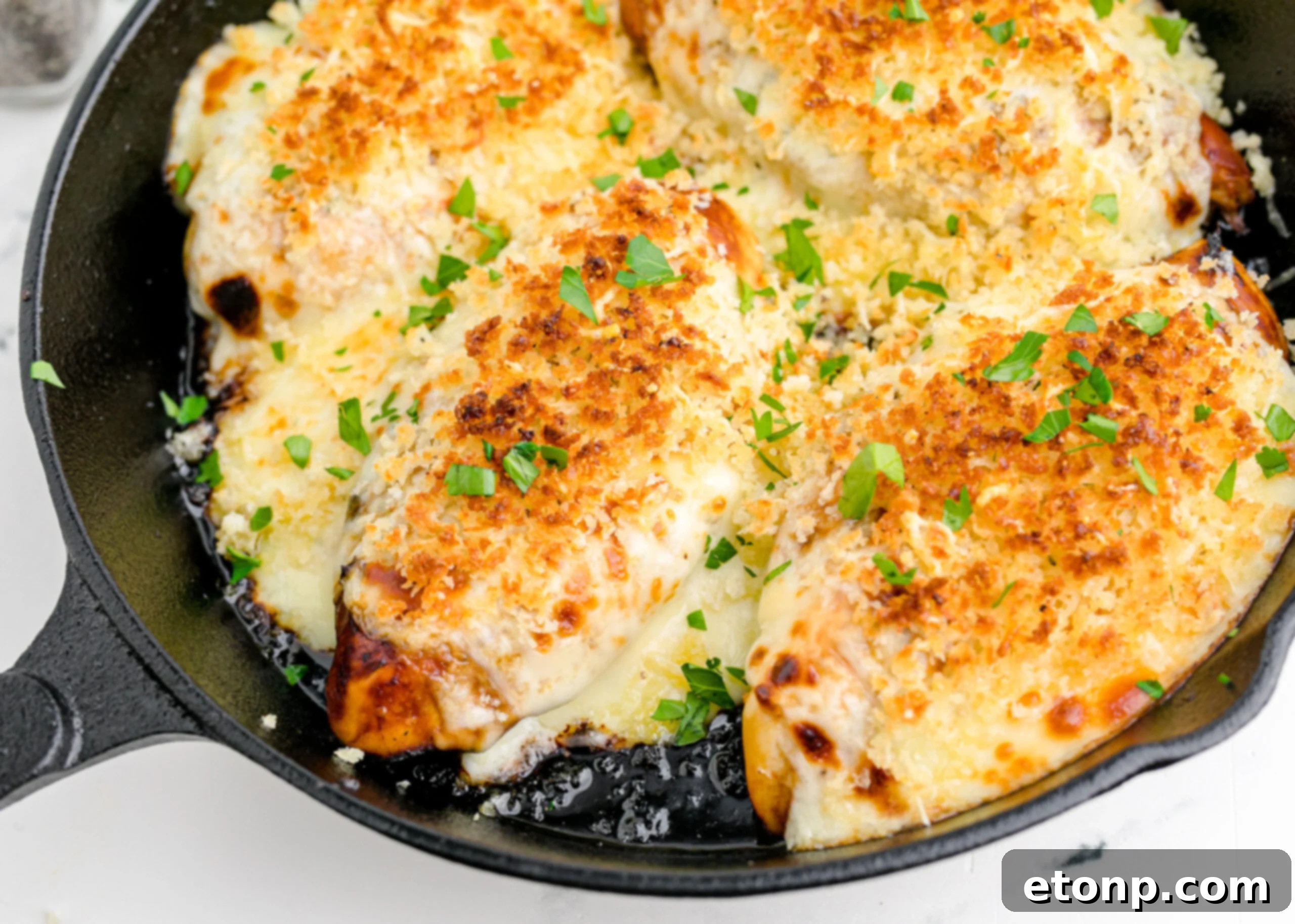 Crispy Parmesan Chicken 15 Close up view of Parmesan Crusted Chicken (Longhorn Copycat) in a cast iron skillet, showing the perfectly melted cheese and crunchy crust.