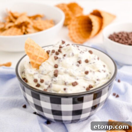 A side view of the luscious Cannoli Dip with a waffle cone in a decorative bowl.