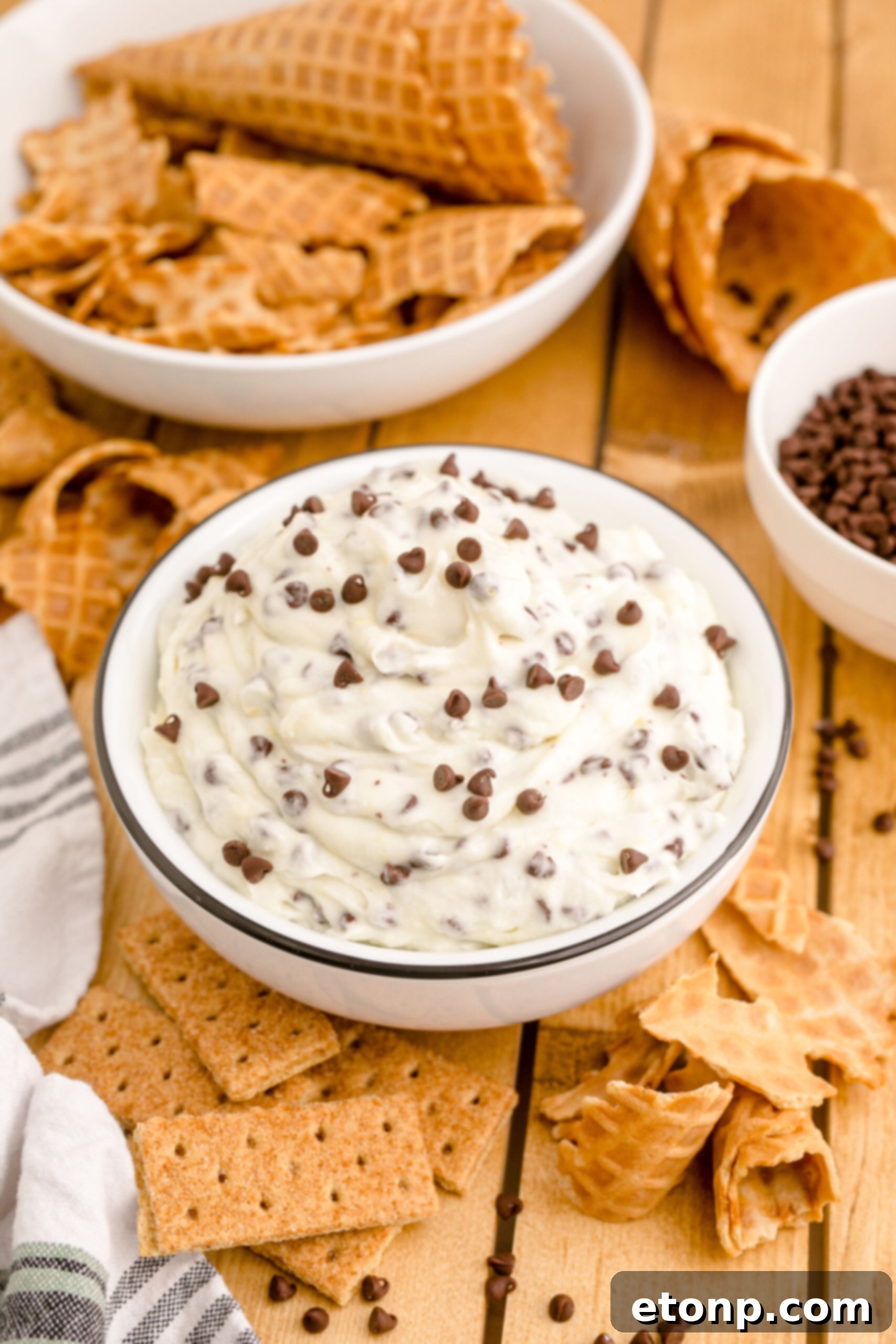 A charming side view of the Cannoli Dip, presented in a black and white dish on a rustic wooden table, ready to be enjoyed.