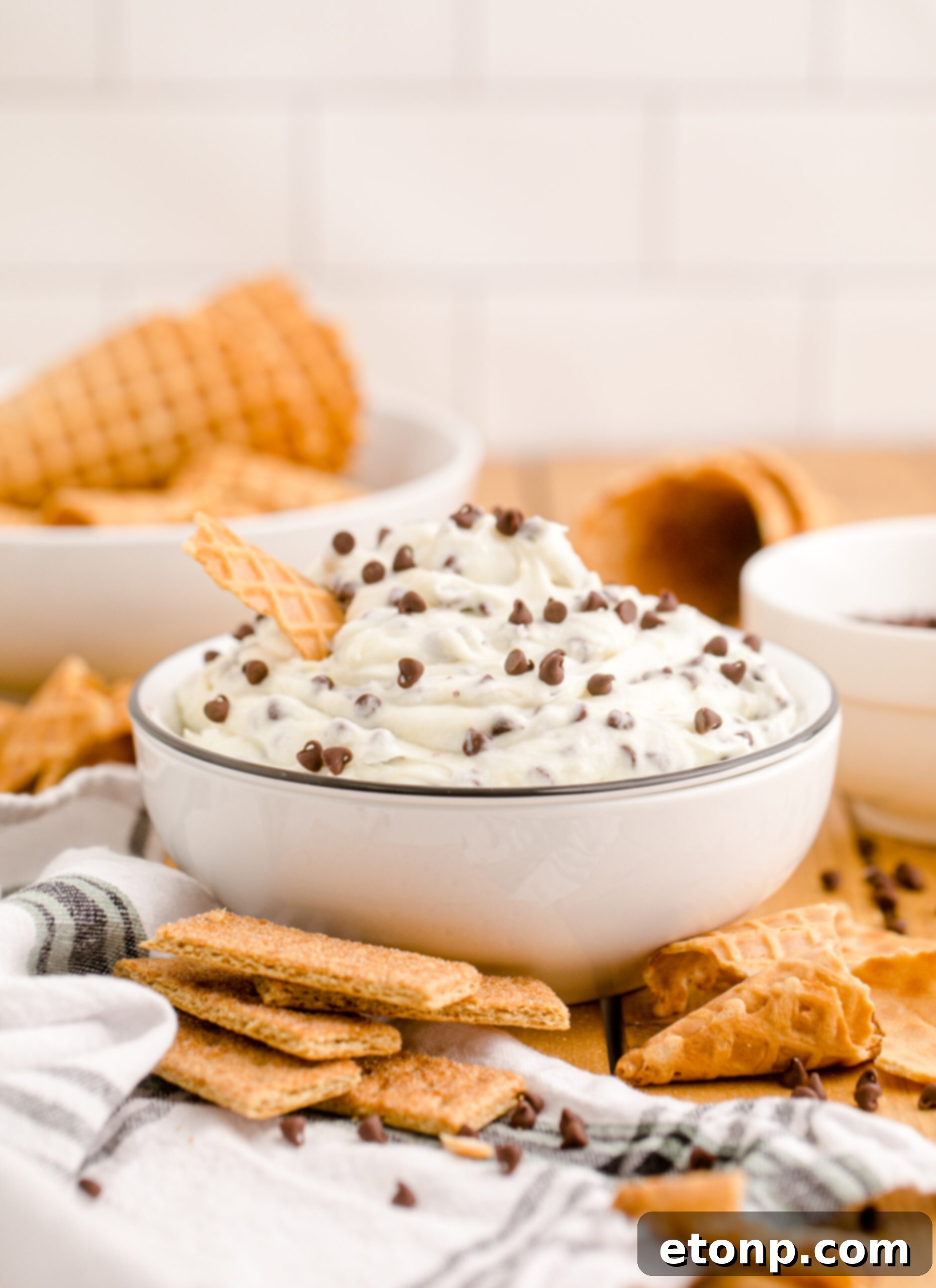 Another enticing side view of the Cannoli Dip, presented beautifully in a black and white bowl with a golden waffle cone, highlighting its creamy texture.