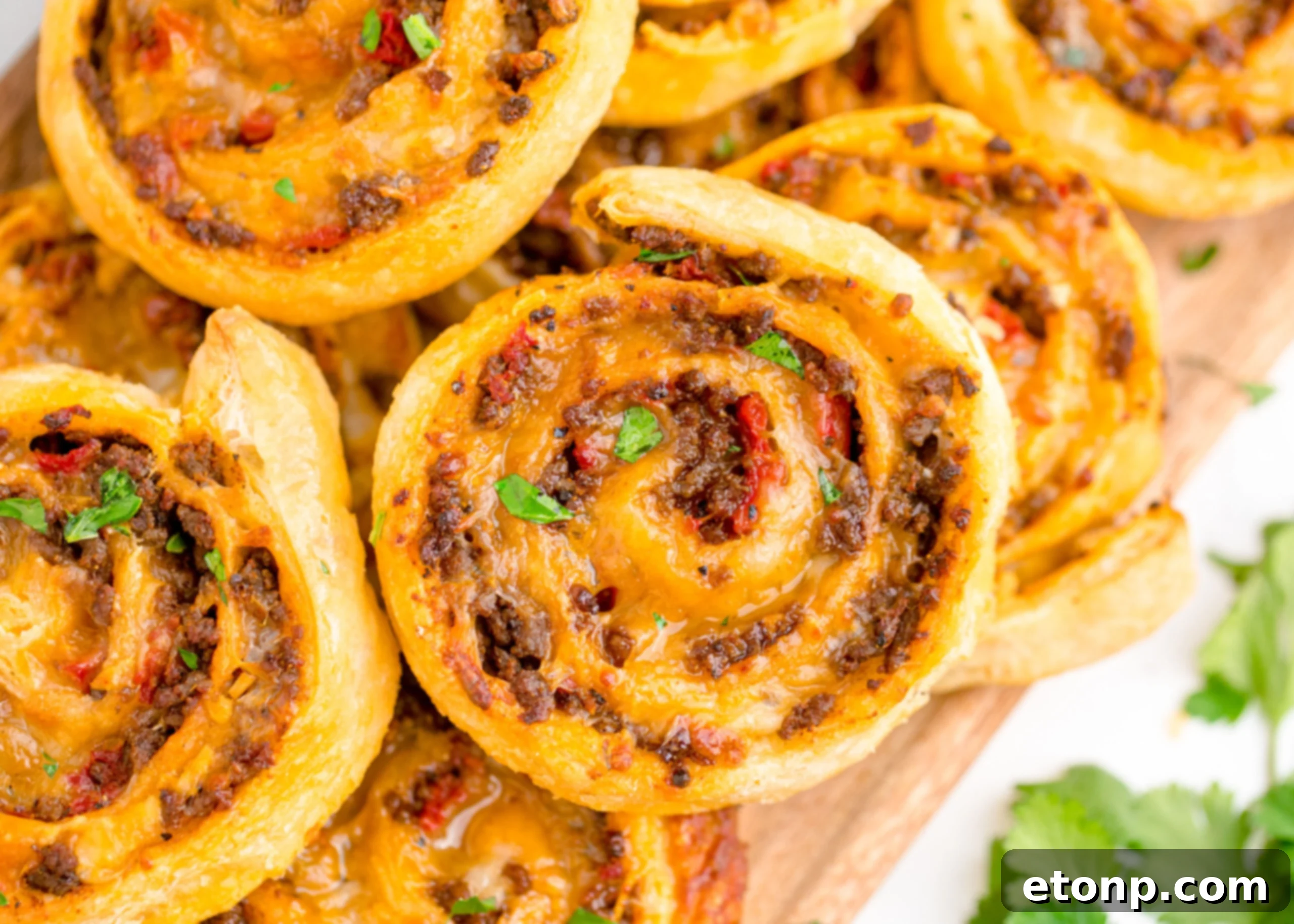 A detailed close-up of a stack of Taco Pinwheels, revealing the melted, gooey cheese and seasoned beef filling inside the flaky pastry.