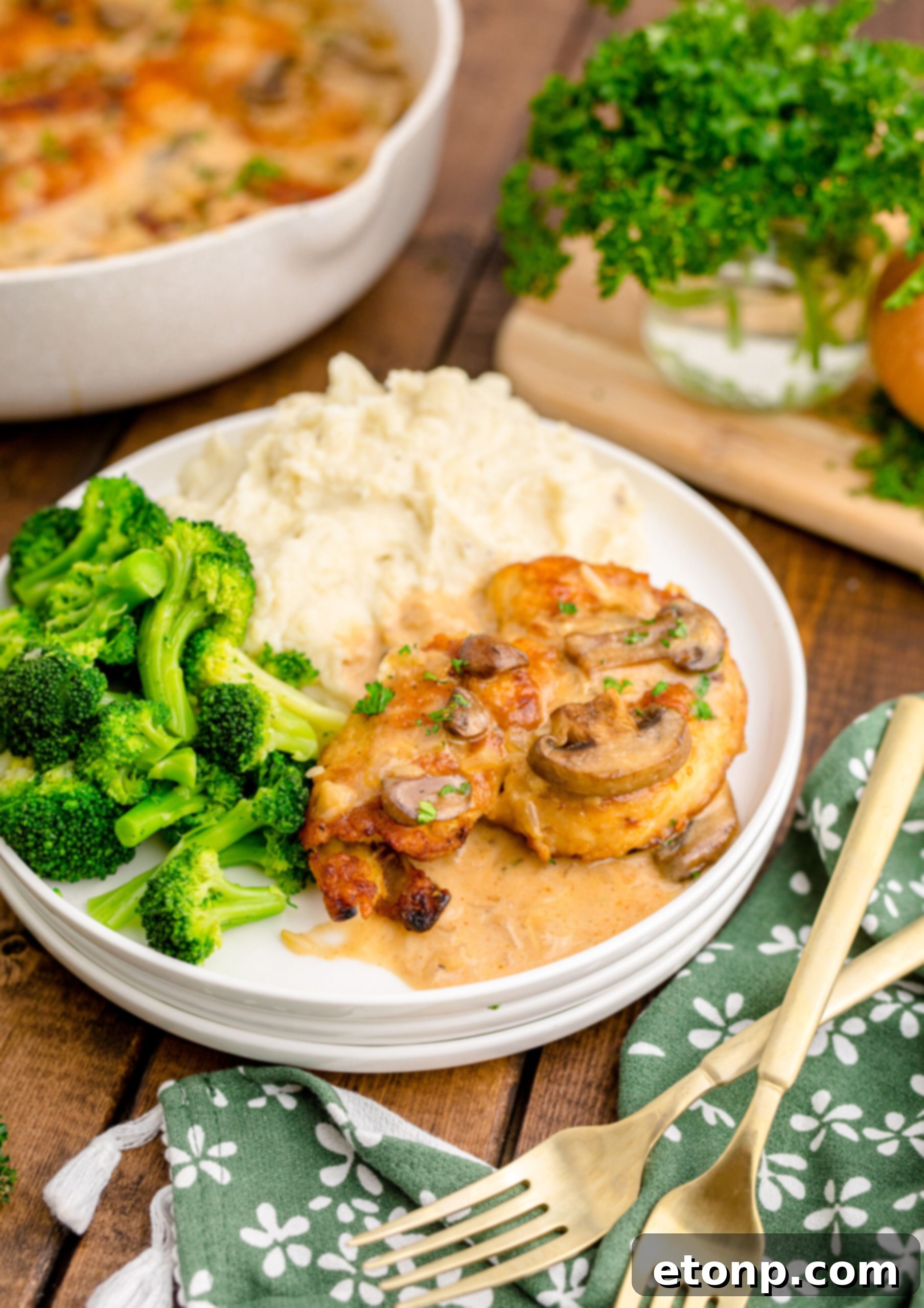 Chicken Marsala on a white plate with a side of broccoli and mashed potatoes 
