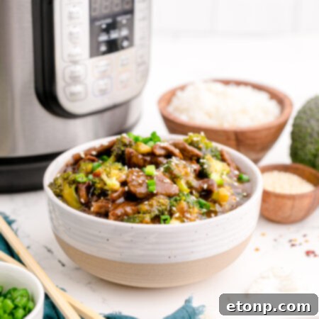 Instant Pot Beef and Broccoli in a white and tan bowl, showcasing the finished dish.