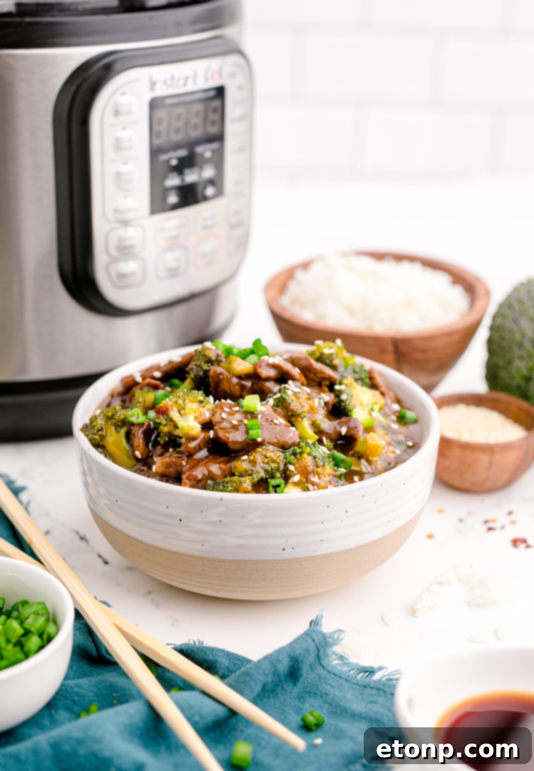 Side view of a serving of Instant Pot Beef and Broccoli in an elegant white and tan bowl, ready to be enjoyed.