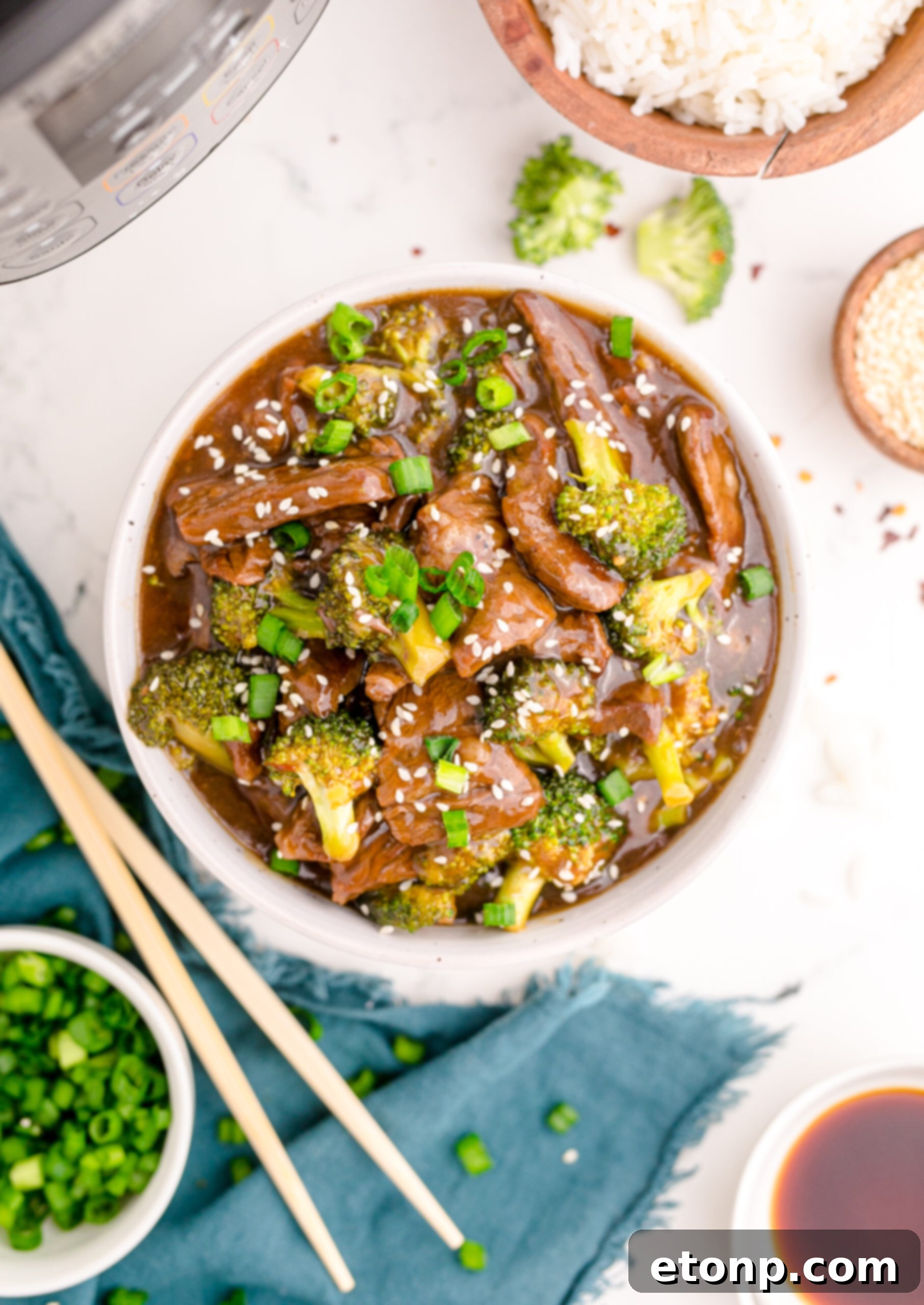 Overhead perspective of a generously portioned Instant Pot Beef and Broccoli in a white and tan bowl, highlighting the colorful ingredients.