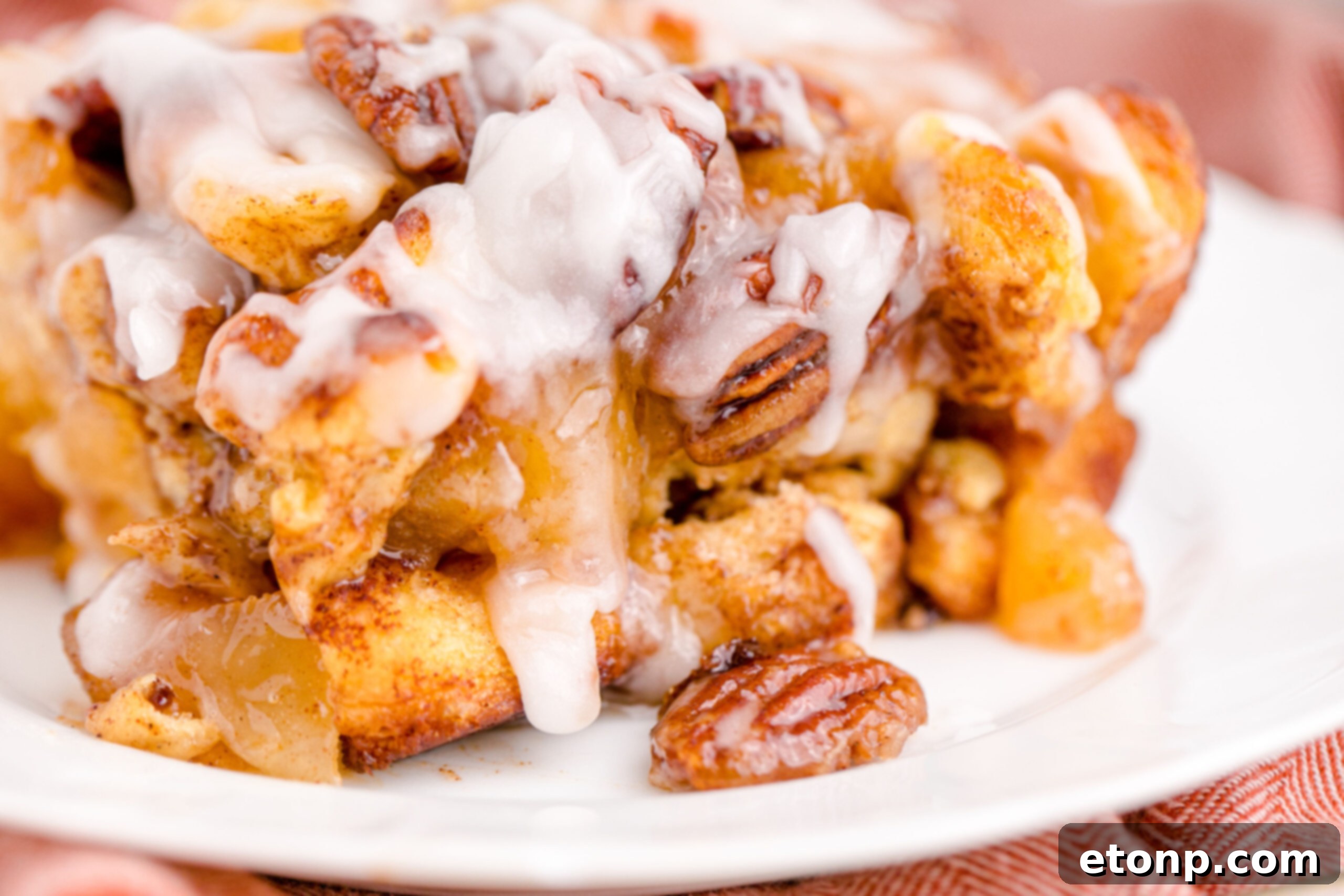 A freshly baked slice of Cinnamon Roll Casserole on a white plate with a gold fork, showing its delicious layers.