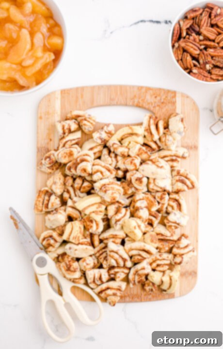 Close-up of cinnamon roll pieces being cut, highlighting their spiral shape.